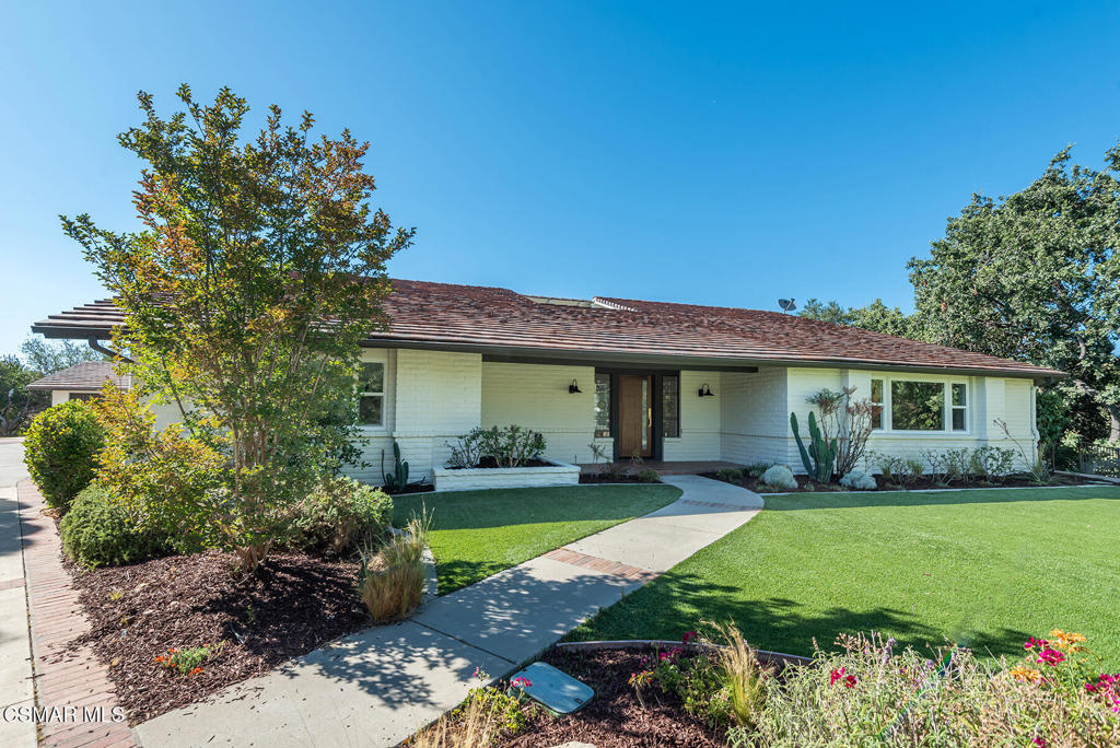When Frank Lloyd Wright set out to design a uniquely American architecture in response to ornate Victorian designs, he chose to accentuate clean horizontal lines featuring an open concept interior while harmoniously integrating the home's natural surroundings. And so the Prairie Style Architectural movement was born. With this in mind, welcome to 1251 Calle Las Casas in magnificent Lynn Ranch. Inspired by Prairie Style elements like the block exterior construction, a broad covered patio with soaring beams and the sensational indoor-outdoor atrium, living in this home is unique, comfortable and connected to its oak tree dotted surroundings. Reimagined for today's lifestyle, the builder has invigorated this home with elegance and grace. Take the Mid Century front door as an example. Open it and you're immediately greeted by the center atrium. Note the original stained glass accents! With windows on all four sides, the atrium floods every space with natural light. The 8' oak floors reflect that light, creating a Zen-like vibe. So inviting! The floorplan offers 2 grand primary suites, sensational for multigenerational living. The baths feature dramatic materials like elegant quartz counters, brushed gold hardware and in keeping with the Wright feel, natural wood cabinets. The kitchen is anything but old world. Opening to the classic Mid-Western inspired great room with the wall length mantel and brick fireplace you'll feel transported. Consider the 8 burner gas range and matching commercial hood, the side by side built in refrigerator-freezer and massive center island. Not only will you relish the time in the kitchen creating culinary masterpieces, but with the stunning bay and huge picture windows, even doing dishes will be relaxing as you gaze over your acre of live and coastal oak trees. There are spacious secondary bedrooms with a stunning Jack and Jill bath between them, a beautiful powder bath and a 2 car garage plus additional 1 car carport. Even the laundry room is exciting. Imagine a rainy day where the mundane folding of laundry is made easier by simply looking out upon the atrium as the rain comes down. The property has peek-a-boo views and even Mt. Boney and the Santa Monica Mountains are visible to the south. The long driveway could be easily gated though this quiet cul de sac location provides ample privacy. And while abutting the Barranca above the Arroyo Conejo Creek (the Conejo Valley's Longest) may sound like you're worlds away, the truth is, you are minutes to the Oaks Mall, Los Robles Hospital and have easy access to the 101 freeway. Properties like this, rarely come on the market and as a one of a kind single story with no interior steps, wide halls and huge spaces, this home is ideal for young and old alike.