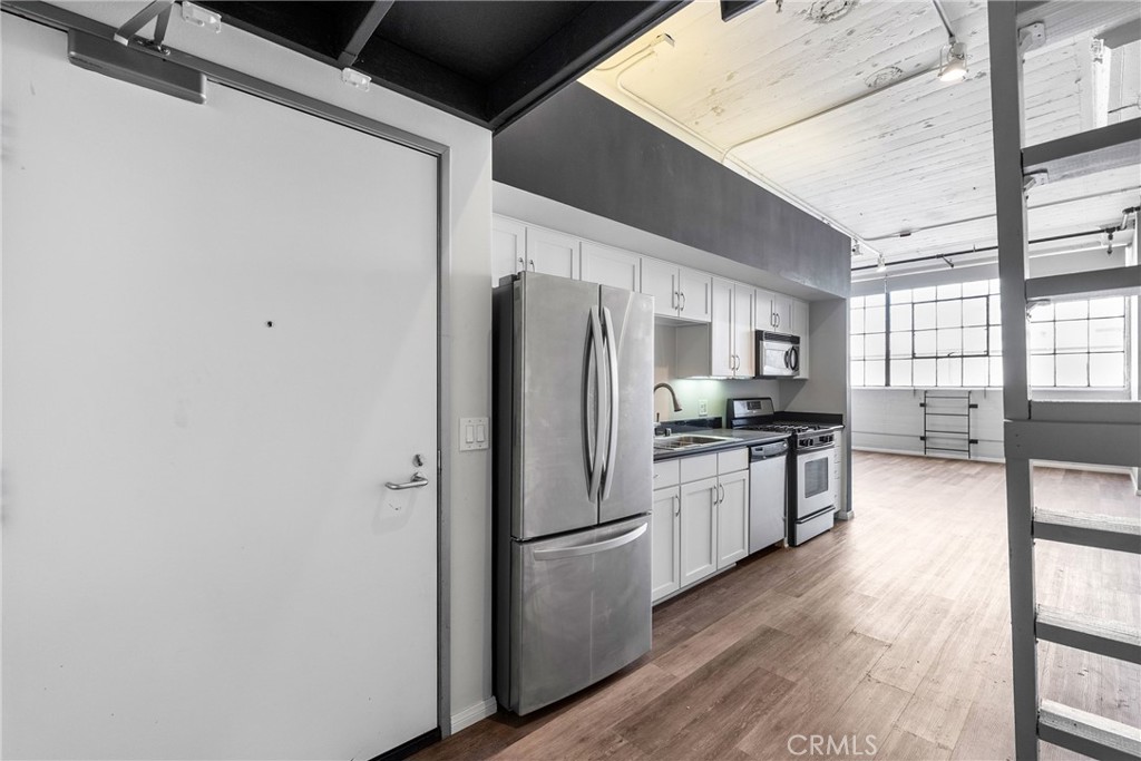 DOWNTOWN LOFT in the chic and sophisticated Little Tokyo Lofts, offering a prime live/work space in a vibrant urban setting. This spacious loft features a large original north-facing casement window that showcases stunning city views, soaring high ceilings, and an eye-catching concrete column. The floors are a stylish mix of hardwood and concrete, adding to the modern industrial charm. The kitchen is equipped with sleek granite countertops and stainless steel appliances, perfect for culinary enthusiasts. The bathroom includes both a bathtub and a separate shower, dual ceramic sinks set into a granite and wood vanity with ample storage drawers, plus a convenient washer and dryer. Additional highlights include generous closet space, with an extra dresser closet included, central heating and air conditioning, and cable and internet hookups. Enjoy private views from the expansive bay windows and make use of an additional loft space for storage or creative projects. The HOA covers water, sewer, trash, amenities and security/parking. Residents enjoy a host of excellent amenities, including an open-air lounge patio, a garden-style heated pool and spa, BBQ and library areas, a fully equipped gym, and a dog run. Security is exceptional with gated entry and a private parking structure. The unit comes with one designated parking space and access to over 25 secure guest parking spots. Nestled in a lively, welcoming live/work community bordering Little Tokyo Village, the Arts District, and Gallery Row, this location puts you within walking distance to top restaurants, shops, supermarkets, and convenient Metro access.