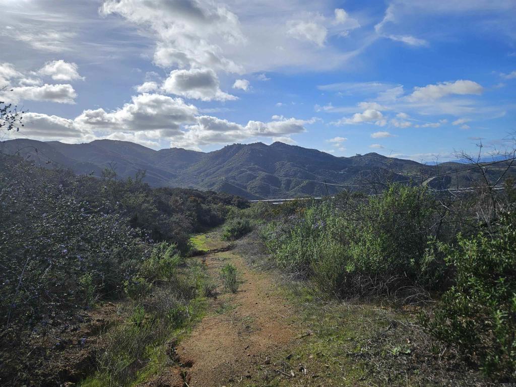 MOUNTAIN VIEWS! MOUNTAIN VIEWS! LOCATION! LOCATION! ABOVE LAWRENCE WELK RESORT IN COVETED ESTATES COMMUNITY OF HIDDEN MEADOWS, ESCONDIDO! RESORT STYLE LIVING WITH ACCESS TO POOLS, TENNIS COURT, GOLF AND CLUBHOUSE. Discover the Pinnacle of Tranquil Living on this Private, Hidden Meadow, Residential lot! Nestled atop North County's finest mountaintops, this 2.43 acre parcel presents an exceptional opportunity to turn your dream home into reality. The land comes equipped with essential amenities, including electric and water ready access for connection. Enjoy breathtaking panoramic views that span from majestic mountains and canyons. Located in the highly sought-after Hidden Meadows community, this haven is situated at the end of a private cul-de-sac, offering a perfect blend of serenity and convenience. As you step onto the property, you'll be captivated by the steep drop-off to the west, ensuring unparalleled privacy and providing endless westerly views of rolling hills, picturesque valleys, and awe-inspiring sunsets. Imagine building your dream home on a lot that not only offers seclusion but also invites the natural beauty of the surrounding landscape into your everyday life. For recreation, the neighborhood boasts two tennis courts, two recreation centers, and an Olympic-sized pool, available for an optional annual membership. Whether you're seeking a relaxing dip in the pool or a friendly tennis match, the amenities add to the allure of this Hidden Meadows gem. Conveniently located near the I-15, this property provides easy access to all that North County has to offer.