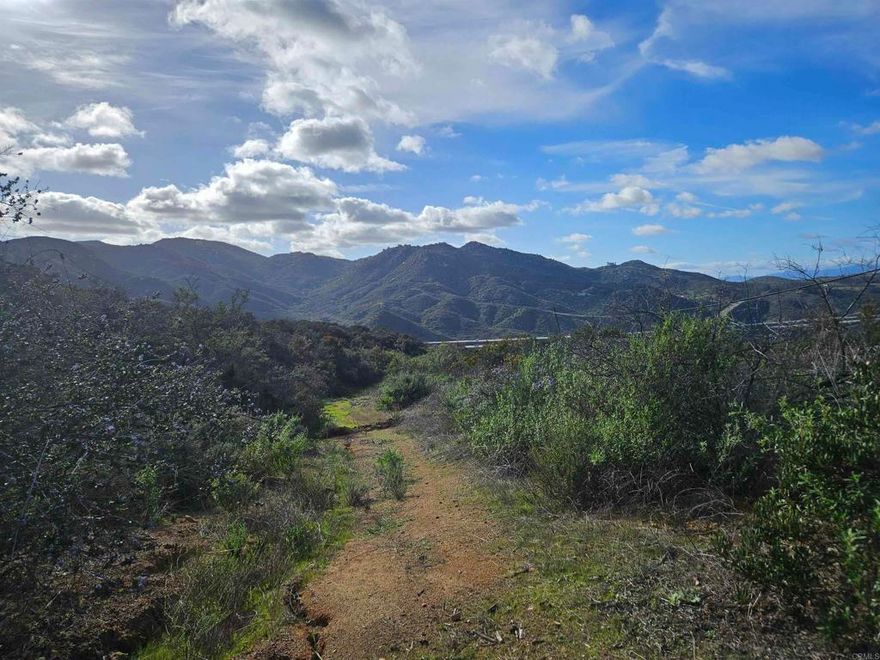 MOUNTAIN VIEWS! MOUNTAIN VIEWS! LOCATION! LOCATION! ABOVE LAWRENCE WELK RESORT IN COVETED ESTATES COMMUNITY OF HIDDEN MEADOWS, ESCONDIDO! RESORT STYLE LIVING WITH ACCESS TO POOLS, TENNIS COURT, GOLF AND CLUBHOUSE.  Discover the Pinnacle of Tranquil Living on this Private, Hidden Meadow, Residential lot! Nestled atop North County's finest mountaintops, this 2.43 acre parcel presents an exceptional opportunity to turn your dream home into reality. The land comes equipped with essential amenities, including electric and water ready access for connection. Enjoy breathtaking panoramic views that span from majestic mountains and canyons. Located in the highly sought-after Hidden Meadows community, this haven is situated at the end of a private cul-de-sac, offering a perfect blend of serenity and convenience. As you step onto the property, you'll be captivated by the steep drop-off to the west, ensuring unparalleled privacy and providing endless westerly views of rolling hills, picturesque valleys, and awe-inspiring sunsets. Imagine building your dream home on a lot that not only offers seclusion but also invites the natural beauty of the surrounding landscape into your everyday life. For recreation, the neighborhood boasts two tennis courts, two recreation centers, and an Olympic-sized pool, available for an optional annual membership. Whether you're seeking a relaxing dip in the pool or a friendly tennis match, the amenities add to the allure of this Hidden Meadows gem. Conveniently located near the I-15, this property provides easy access to all that North County has to offer.