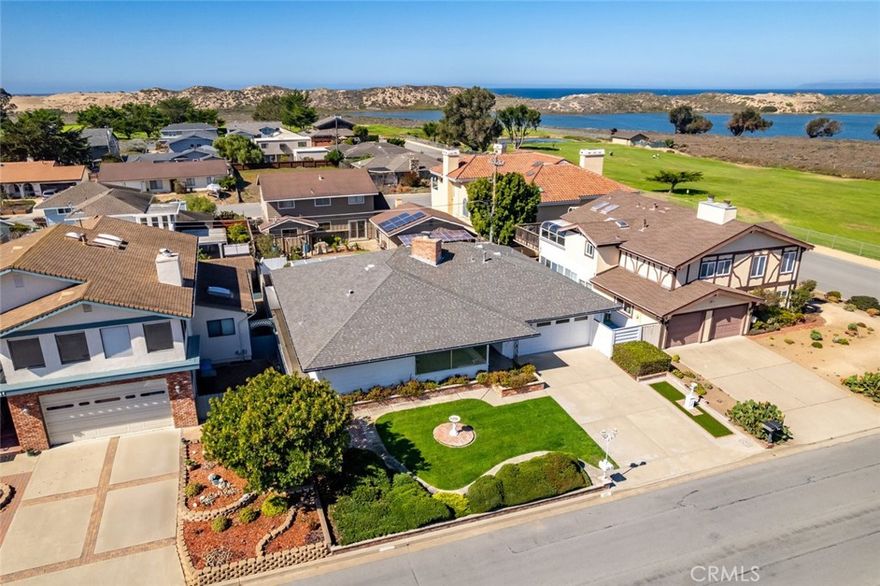 Located in the highly desirable Sunset Terrace neighborhood, this mid-century single-level home is ideally situated just moments from the bay, the Los Osos sand dunes, and directly across from Sea Pines Golf Resort—offering easy access to the best of coastal living and outdoor recreation.
From the moment you arrive, you’ll be captivated by the beautifully landscaped front yard—complete with manicured hedges, lush lawn, brick-accented flower beds, and a graceful concrete walkway that leads you inside.
Step into the spacious main living area, where sweeping views steal the spotlight through expansive picture windows. A wood-burning fireplace with a uniquely designed floating hearth and partial room divider adds warmth and architectural interest.
The elegant dining room is crowned with stunning chandeliers, setting the stage for unforgettable dinners and intimate gatherings. The kitchen boasts ample cabinetry, generous granite counters, and modern conveniences including dual ovens, cooktop, microwave with range hood, refrigerator, and dishwasher. Just off the kitchen, a cozy breakfast nook is perfect for morning coffee.
Additional highlights of the home's main living areas include an atrium-style sun room, ideal for soaking up natural light or cultivating your green thumb, and an office nook. 
The primary suite offers direct access to the backyard and a private ensuite bathroom with a shower with tub, vanity with seating, and a spacious closet. A second bedroom also opens to the backyard and shares a beautifully appointed second bathroom with built-in storage and linen closet. A third bedroom adds additional versatility.
Out back, enjoy your own private putting green—a golfer’s dream.
Additional highlights include a large two-car garage with built-in storage and all the charm and functionality of classic mid-century design.