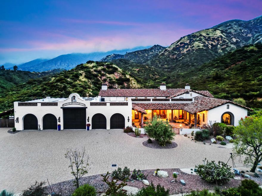 Vibrant, character-rich interiors unite with lush, beautifully manicured grounds at 4770 Flat Riv,a genuinely inimitable, hilltop Spanish-style estate set over three acres in Claremont. Perched at 2,000 feet overlooking rolling foothills, the city, and Mount Baldy in the distance, this five-bedroom, seven-bath estate spans 7,930 square feet and presents ample opportunities for sophisticated, unforgettable entertaining, and invigorating everyday living. Past privacy-enhancing gates, the home's entry courtyard is replete with custom tile murals, a fountain, and Sonoran-inspired landscaping. Find barrel and vaulted wood-beamed ceilings, reclaimed wood floors, and custom homes. The living spaces open seamlessly to the resort-like covered outdoor patio, which leads to a pool and spa and frames sweeping, far-reaching hill, valley, and mountain views. A stone's throw from the estate's patio is mature fruit trees; a flourishing rose garden and 90+ vineyards. Additional home features include 96 solar panels, multiple security cameras, an indoor/outdoor sound system, a whole house central vacuum system, a backup generator, a four-car garage, an RV garage that can accommodate a 40-foot vehicle, a Starlink satellite, and much more. Adding to its phenomenal appeal, 4770 Flat Riv is mere minutes from local markets, shops,parks, and main thoroughfares, including I-210 and I-10.