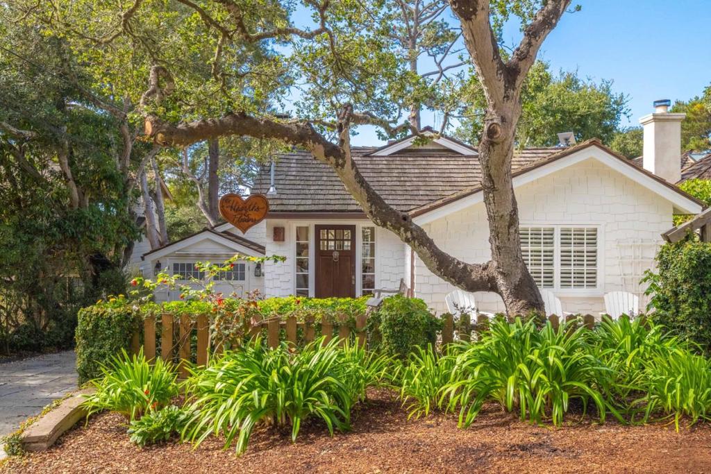 Nestled in the Golden Rectangle and just a short stroll from Carmel Beach, this coastal cottage has been thoughtfully reimagined to blend classic Carmel character with upscale modern living. Step inside to discover a light-filled living space anchored by a rustic stone fireplace, creating the perfect setting for cozy evenings or relaxed entertaining. The stylish, updated kitchen flows seamlessly into the open living area, while a charming loft above adds a whimsical touch, ideal as a reading nook, creative space, or guest area. The private primary suite offers a peaceful retreat with a spacious walk-in closet, while a beautifully appointed guest suite ensures comfort for visitors. A third bedroom, paired with a convenient half bath, is perfectly suited for a home office or additional overnight guests. Every corner of this home is enhanced with custom finishes and details that elevate its sense of luxury. Enjoy ocean glimpses from the balcony or unwind in the lush, landscaped backyard, an ideal setting for alfresco dining or entertaining. This hidden gem is the perfect Carmel retreat, ideally situated to enjoy the best of Carmel-by-the-Sea's vibrant downtown and scenic coastline.