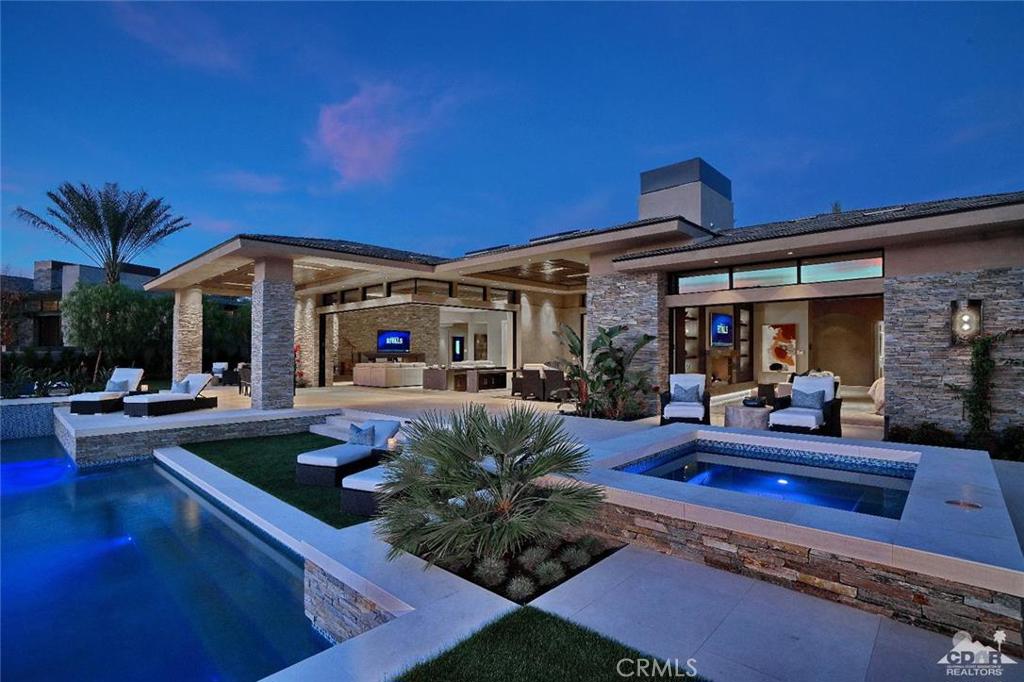Desert contemporary on a Southwest facing home site at The Madison Club! Private courtyard showcases dramatic fire and water features along with an oversized glass entry door that draws you into this amazing property. This expansive home offers 5 bedrooms, a state-of the art theater, office, wine room and 5.5 baths. Second floor has a separate living area with fireplace, wet bar and 2 well-appointed guest suites. Open floor plan has numerous sliding glass walls allowing a seamless indoor/outdoor transition. Kitchen offers high performance appliances, an oversized island and breakfast bar. Lavish master suite has a fireplace, his and her walk-in closets and spa inspired bathroom. Custom outdoor cook center and living space makes entertaining easy along with an extended patio that surrounds an infinity edge pool and spa. This fully automated home is offered furnished as per inventory.