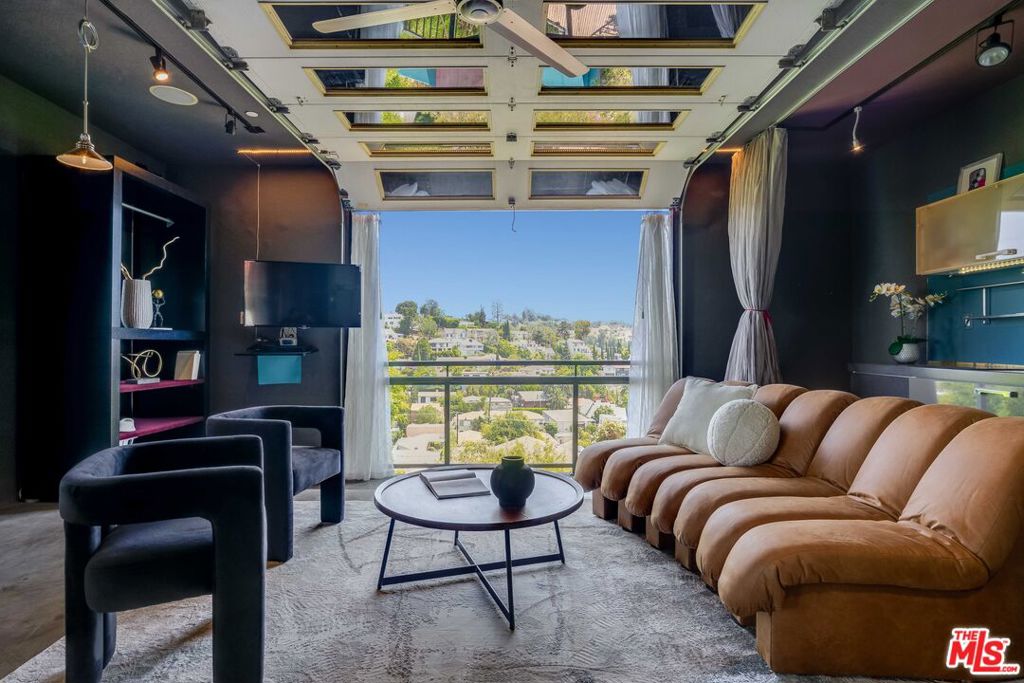 Welcome to a Japandi styled retreat nestled in the hills of enchanting Beachwood Canyon. A harmonious blend of dark and vibrant Japanese design elements combined with an industrial aesthetic, this home stands out from the rest. Spanning nearly 3,000 square feet and perched above the city this home is framed by open decks and lush landscaping to soak in the scenery of the hills. Upon entering the gates of this home, you are greeted by oversized bamboo and step over a bridge to enter a living room that boasts views of the Hollywood Hills, Griffith Observatory, Downtown, and the iconic Hollywood Sign. Fantastic indoor outdoor flow with multiple oversized industrial doors to take in the hills views or the bamboo gardens. The oversized doors give the feeling of floating in the clouds! Perfect for hosting, the first floor of the home features a sophisticated Bulthaup- style wet bar in the living room and an open kitchen and dining room with views. There is also a junior suite bedroom and bathroom located on the first floor that is a playful pink color to match the kitchen and the dining room aesthetic. A second bathroom on the first floor with floors and shower walls all of polished concrete rounds out the space. The lower level of the house has a separate entrance that offers great potential for an Accessory Dwelling Unit (ADU). This level includes two bedrooms and two bathrooms, a secondary prep kitchen, a cozy den, and home office capturing the hillside views. Each bedroom has a mixture of vintage timber flooring and concrete floors that lead out to a wrap-around wood deck that spans both the bedroom and lower level living spaces. All the flooring on the lower level is radiant flooring . Off the lower level there are unique wood patio doors designed to look like Japanese temple style doors. Exterior custom metal panoramic doors hand crafted by Japanese artisans break up the various wood deck spaces for additional privacy. The lower level also features a home office space but it can also serve as a third bedroom space on the lower level. All the bedrooms and rooms on the second floor have exterior deck spaces that walk out to the back yard. There is also a third lower level deck with the pool. The lowest level deck and pool need cosmetic upgrades to a Wabi Sabi style pool. This home also features an attached two car garage, ample gated driveway parking, lush landscaping with its tropical vegetation and koi ponds, tankless water heater, and security cameras throughout. There is also ample street parking for guests. Whether you're an artist seeking some fun creative inspiration or simply desiring a peaceful escape, this residence invites you to make it your own.