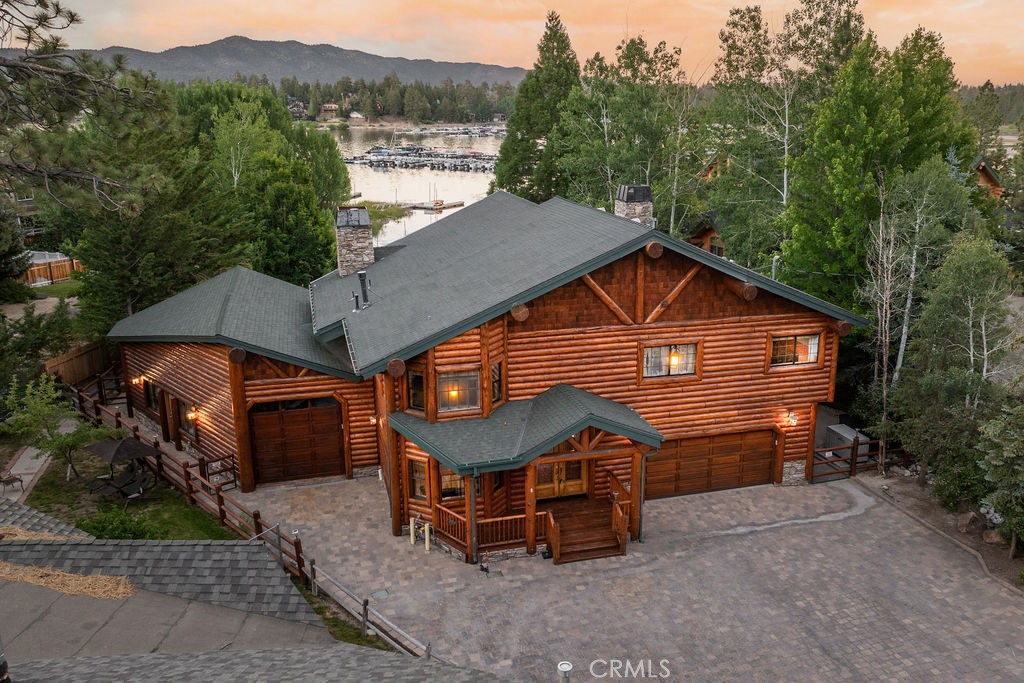 Tucked away on a beautifully landscaped, lakefront lot just steps from Pleasure Point Marina, this luxury rustic cabin blends comfort, style, and that true Big Bear charm. With nearly 70 feet of lake frontage and over a third of an acre of usable land—including a lush grassy backyard—it’s the kind of place that invites both adventure and relaxation. Inside, you’ll find over 3,400 square feet of remodeled living space featuring 4 bedrooms and 4 bathrooms, including a spacious master suite. The open layout includes vaulted wood-beam ceilings, a stunning wall of glass framing the lake, a large loft with stunning views, and a cozy den/movie room perfect for winding down after a day on the water. Step outside to an expansive deck built for entertaining right on the lake. There’s a private spa tucked into the backyard, a sauna for those crisp mountain evenings, and two oversized garages with plenty of space for lake toys, gear, or extra guests. A Generac generator is already hooked up and ready to go—this place is built for year-round living and peace of mind. Whether you’re watching the sunrise from the deck or hosting friends under the stars, this home delivers the lake lifestyle without compromise. A rare opportunity in one of Big Bear’s most coveted waterfront pockets.