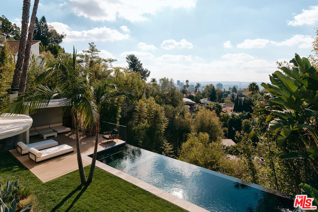 Designed by award-winning AIA architect Lorcan O'Herlihy, this 1946 Streamline Moderne home has been elevated into a masterpiece of modern luxury. Fully furnished and available for lease, the property features 3 en-suite bedrooms, an expansive deck, an infinity pool and hot tub, and a stylish outdoor cabana with a fireplace, all set against breathtaking jetliner city-to-ocean views. The open-concept layout flows effortlessly between the spacious living area and designer kitchen, with soaring ceilings and walls of glass filling the home with natural light. Surrounded by lush landscaping and complete with a two-car garage, this Hollywood Hills retreat offers both privacy and sophistication.