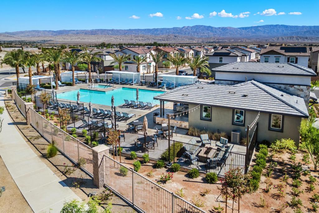 Discover modern elegance at this stunning Lennar-built 2-story residence in the desirable University Park master-planned community, completed in 2022. Offering 2,032 SF of thoughtfully designed living space & chocolate mountain views, it features 4 bedrooms and 3 full baths-including a convenient guestroom on the main level & 3 spacious bedrooms upstairs. Step inside to a harmonious open-floor layout where the Great Room, dining area & chef's kitchen beautifully flow together. Abundant natural light & seamless indoor-outdoor access create a perfect setting for entertaining & relaxing. The kitchen boasts gray cabinetry paired with Miami Vena quartz counters, complemented by a large walk-in pantry & modern appliances including a double oven & tankless on-demand water heater. Retreat upstairs to the luxurious owner's suite, complete with a spa-inspired bathroom & generous walk-in closet, offering comfort & sophistication. Additional highlights include recessed lighting & smart-home features powered by owned solar panels. Outside, enjoy covered patio living with mountain views & an opportunity to create your own private backyard haven. Community amenities include a recreation facility with kitchen, BBQ's & outdoor dining, plus pool & spa with large fire pit area & lounging cabanas throughout-all set amidst desert palms, landscaped surroundings & close to premier golf & upscale shopping & eateries.