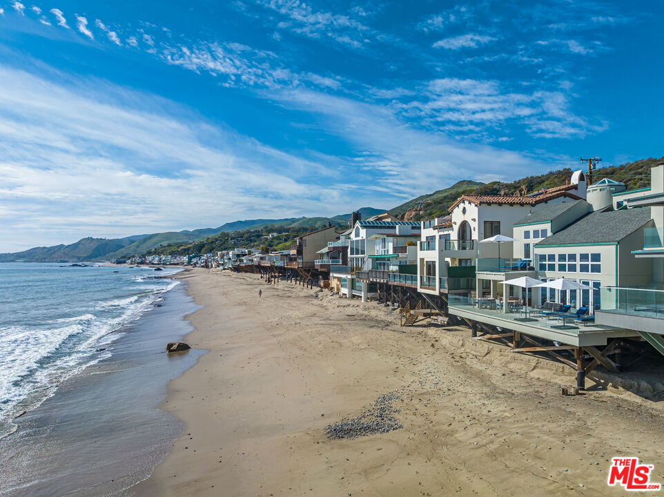 Enjoy the ultimate Malibu lifestyle with stunning unobstructed ocean views from this private architectural beach home located on a sandy section of Malibu Road. Set behind a gate, enter a private courtyard achieved by lush greenery, fountain and immaculate architecture with direct beach access. Inside, the spacious open concept living area opens up to an oceanfront deck made for entertaining with BBQ, an al-fresco dining area and plenty of outdoor lounging. The home boasts floor to ceiling windows, great natural light and high ceilings throughout. In addition to the open concept main living areas the first floor features a guest bedroom and bath. Upper floor features a stunning ocean view primary suite with an oversized balcony to take in the sunsets, as well as a second guest bedroom. Upstairs enclosed loft can be utilized as the 4th bedroom, gym or home office. Ideal close-in location located moments from Nobu, Soho House, shopping and hiking trails. Summer 2026 rate to be $75,000/ Month.