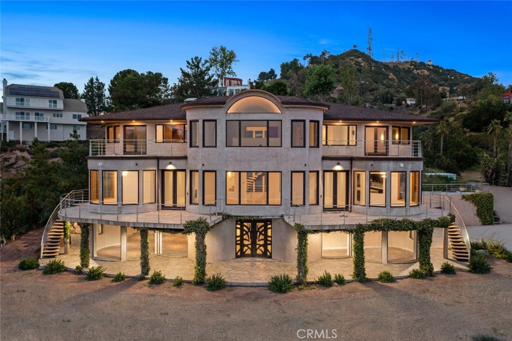 Welcome to a breathtaking private paradise where nature's splendor reaches unparalleled heights. Nestled on 3 sprawling acres in the stunning Santa Monica Mountains, this serene sanctuary offers a dreamlike escape for discerning connoisseurs. Enjoy mesmerizing panoramic views of Santa Catalina Island, Santa Barbara Island, and the sparkling Santa Monica Bay from every level of this exceptional residence. Spanning an impressive 8,617 sq. ft., this home seamlessly blends grandeur and intimacy, featuring 4 opulent bedrooms, 5.5 luxurious bathrooms, and a sophisticated private office. Indulge in leisure with a spacious game room/theater, a generous three-car garage, and an expansive bunker/storage room, ensuring every desire is effortlessly met. Experience exquisite luxury in every detail, with spa-inspired en-suite baths boasting relaxing jacuzzi tubs, expansive walk-in closets, and individually zoned heating and air conditioning for ultimate comfort. The chef's kitchen is a culinary masterpiece, equipped with stunning custom granite countertops, a state-of-the-art built-in refrigerator, a chic wine fridge, and a cozy breakfast nook, making it perfect for culinary enthusiasts. Modern amenities abound, including a sophisticated full-home speaker system, advanced security cameras, comprehensive WiFi coverage, a convenient room-to-room intercom, and an alarm system for peace of mind. This extraordinary residence is truly one-of-a-kind, ideal for those who demand the finest luxuries in life.