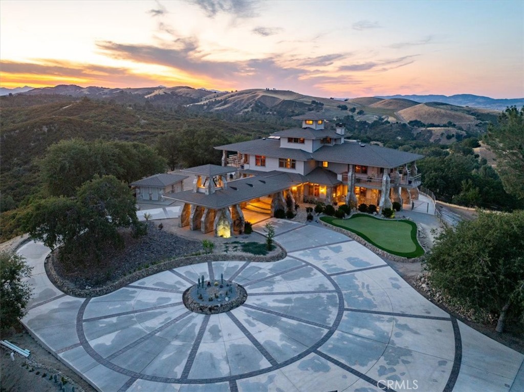 Welcome to your private sanctuary atop 40 acres, offering breathtaking 360-degree views, tranquility, & modern luxury. From the Santa Lucia Mountains to expansive horizons, enjoy stunning sunrises, sunsets, & skies filled with thousands of stars; an astronomer’s paradise. The environment is an ultra-quiet sanctuary with birds, crickets, & wind, creating a peaceful retreat. Paved access makes driving in and out effortless, with additional nearby parcels: an 80-acre open land & a 20-acre hilltop ready-to-build site, included in the sale.
The 5,100 sq ft, three-story home features a spacious design blending comfort & elegance. Highlights include a multi-level library with a large skylight, & a luxurious master suite with a built-in king-size bed, cherry wainscoting, & custom closets. The gourmet kitchen boasts granite counters, cherry cabinets, & Viking appliances. Throughout, Hickory hardwood floors, marble accents, and radiant floor heating elevate the interior, complemented by mini-split AC units and a Hearthstone Mansfield wood stove for winter comfort.
The property offers extensive amenities: over 2,000 sq ft detached garage with a 47’ RV bay, built-in cabinetry & custom woodwork in the main home, a helipad, and a 300 sq ft outbuilding with Tesla Powerwalls, inverter, & storage. State-of-the-art energy systems include solar panels with Tesla Powerwalls, and a Generac generator. Two wells & a 500-gallon propane tank support utilities and add to the property's appeal.
Outdoor living spaces are perfect for entertaining—1,500 sq ft concrete patio, 5,000 sq ft flagstone deck surrounding the house, & a 400 sq ft observation deck on the third floor. The front yard features a putting green ,gorgeous landscaping, & the entire estate is enclosed by a deer fence with five gates & graded roads for easy access. Wildlife is abundant, including deer, foxes, upland game, & songbirds.
Additional features include a light-filled hobby room, laundry with farm sink, and a grand entrance with a cast-in-place basement with arched ceiling complete with a heavy steel combination vault/safe door. Architecturally, the home showcases a porte-cochere with belltower & a bronze bell cast in the 19th century.
Experience wildflowers in spring, bird songs, the serenity of this timeless retreat. Offering a rare blend of natural beauty and modern comfort, this luxury estate is ready for your private tour. Contact your Realtor to schedule today!