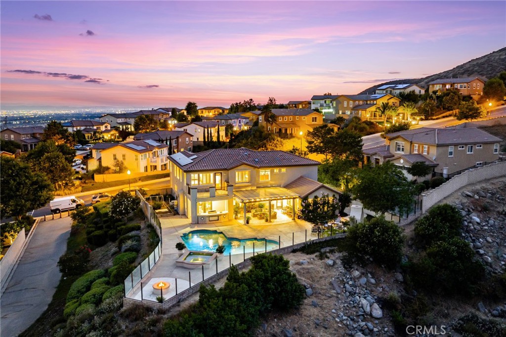 Welcome to Panorama Estates—an exclusive gated enclave of just 50 homes where opportunities like this are rare. This is one the community’s largest floor plans, thoughtfully designed with 4 bedrooms, including a private downstairs en-suite, plus a spacious upstairs loft with built-in office space. The gourmet kitchen is a showpiece, featuring a center island, high-end appliances, and abundant cabinetry that opens seamlessly to the formal living and dining areas. The primary suite is a true retreat with a sitting area, spa-inspired bathroom, and a walk-in closet with premium built-ins. Step outside to your own resort: a sparkling saltwater pool, spa, and glass-enclosed yard that offers sweeping, unobstructed views of Rancho Cucamonga, Fontana, and all the way to Big Bear. An enchanting outdoor fireplace and garden beds enhance the ambiance. With a fully paid solar system and a setting that delivers privacy, luxury, and endless vistas, this home is the pinnacle of elevated living.