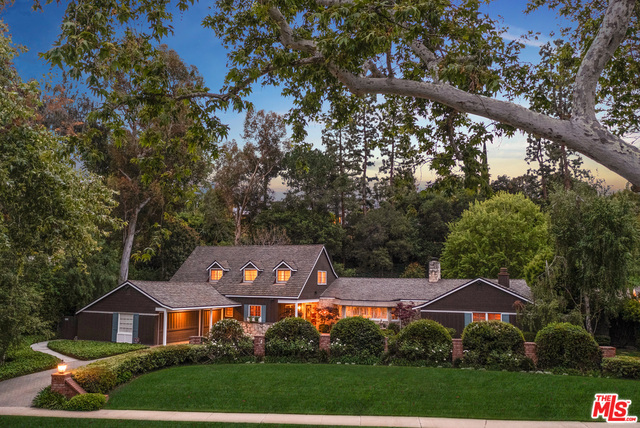 Located across from Holmby Park on a one acre lot in Little Holmby sits a timeless 2 story California Ranch styled home. This woodland retreat permeates charm with a lush backdrop of mature landscapes and California forestry. Immediately greeted by a pitched wood-beamed living room with a wet bar and brick wood-burning fireplace, the home exudes charm and character. A sun-kissed kitchen with upgraded appliances leads effortlessly to a chandelier-lit formal dining room both rooms with direct patio access. The first floor includes a captivating primary en-suite which showcases an oversized walk-in closet, spa-like bath and calming garden views, a den/media room with fireplace, a custom wood-panelled office with en-suite bath as well as a maid's room/additional bathroom. Two further bedroom suites grace the second floor. Designed for leisure and privacy, enjoy your backyard brick patio, stone pool/spa, putting green and separate pool house completely surrounded by lush greenery and manicured landscaping.