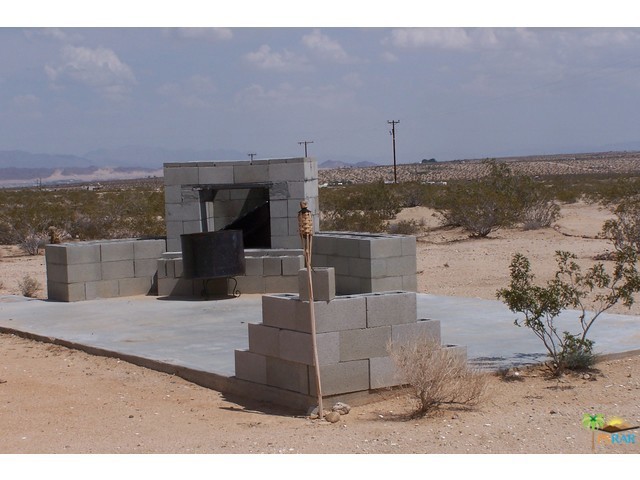 This is a great 5.0 acre parcel of land, up high on the Mesa with spectacular views. The sellers started making this outdoor fireplace and would be outdoor kitchen. They spent weekend here in their RV. They made a circular driveway on the property, created an entrance and road up to the building pad that the fireplace is sitting on. Their plans have changed and they moved out of State, so must let this wonderful setting go. They had a water meter put in and the drop down pole for power is still on the property. There is no light pollution here, so star gazing is amazing. The property has easy access after you leave the paved road. It is centrally located so you can be in Twentynine Palms to the new Casino, downtown Joshua Tree to enter the Park or downtown Yucca Valley in a short period of time. This one is a must see, Don't Wait - Call Now!!