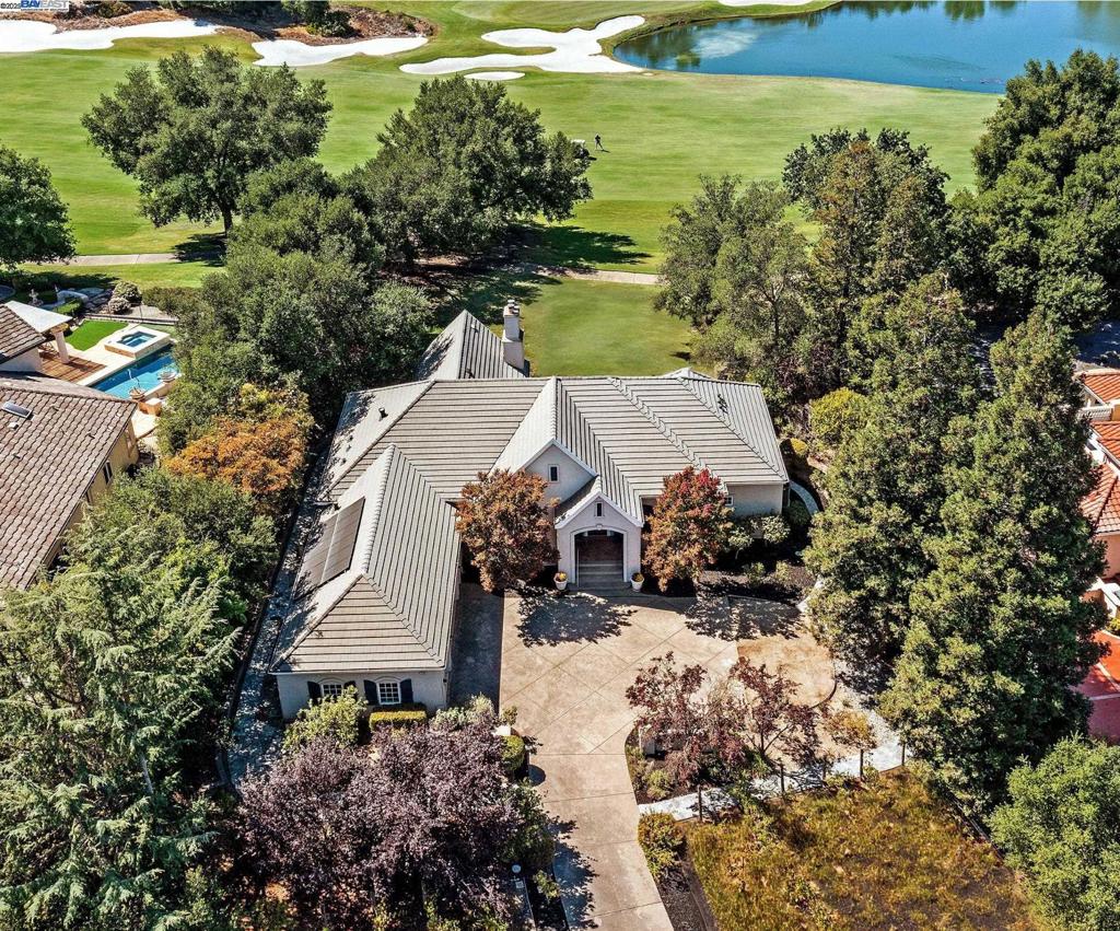 Welcome to this exceptional, single-story custom home in Pleasanton’s prestigious Ruby Hill community. Perfectly situated on an expansive east-facing lot, this home backs to the 5th fairway and offers breathtaking views of the lake and golf course. Inside, soaring ceilings and walls of windows fill the bright, open floor plan with natural light. The chef’s kitchen is the heart of the home, showcasing a massive island, stainless appliances, and effortlessly flows into the spacious family room. Multiple living areas seamlessly transition to the outdoors, where patios and open entertaining spaces create the ultimate setting for your gatherings. The property is a hobby vintner’s dream, featuring a private vineyard – complete with wine making equipment. The sprawling lot also provides plenty of room for a potential ADU. A 3-car garage plus golf cart garage complete the home’s thoughtful design. Residents of Ruby Hill enjoy resort-style amenities including a clubhouse, pools, tennis, basketball, and more. Families benefit from highly rated Pleasanton schools, while the community’s ideal location provides easy access to Downtown Pleasanton, Downtown Livermore, Hwy 84, hiking and biking trails, and world class golf. Don't miss this opportunity for a gorgeous Ruby Hill home.