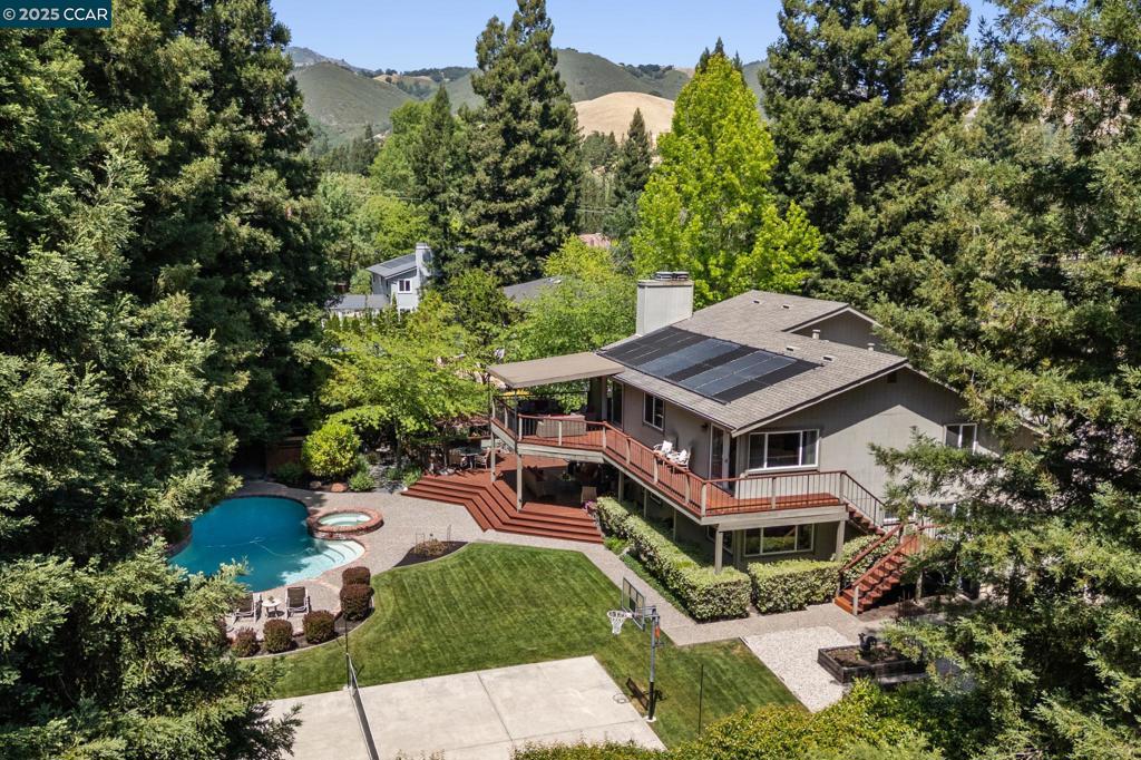 This extraordinary East facing Woodcreek Estate home sits on a sprawling 19,200 sq ft lot perfectly balanced with style and opportunity. A peaceful & prestigious warmth is found in the main home with in-law guest quarters with private entrance, multiple covered decks & built-in BBQ kitchen for outdoor living, basketball, pickle ball, volleyball sports court, bocce ball, pool, hot tub, raised garden bed, expansive gardens and lawn. The superb no outlet community & location has beautiful Diablo views. The beautiful location, tucked in on a large flat lot is surrounded by mature tress and presents even larger than life with its grand foyer, vaulted ceilings, double staircase, and many windows. Gorgeous White Oak hardwood floors, 2 cozy fireplaces with stone facades. Primary suite features yard access & deluxe spa bath, his and hers sinks, 3 closets, heated floors and elegant fixtures. Secondary bedrooms over look the backyard with access to large bathroom complete with private commode and dual sinks. The chefs kitchen is light and bright with a beautiful garden window and bay window bringing the outdoors in. The in-law unit is equipped with a bedroom, den, bathrooms with dual sinks and kitchenette. It has its own private access.