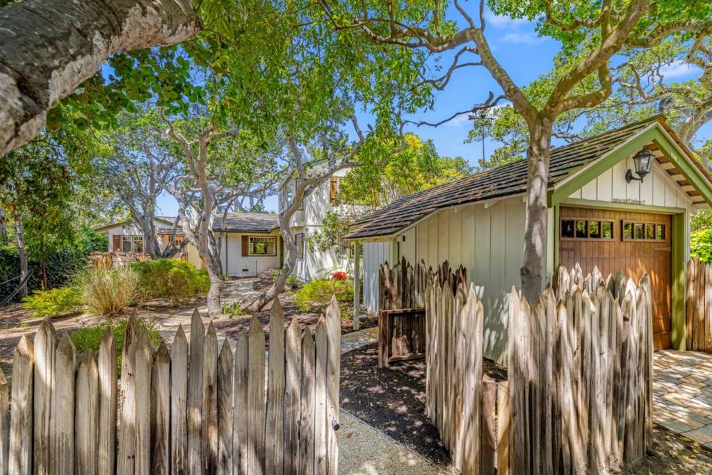Just four short blocks to the beach and a level 5 block walk to town 'Casa Can't Believe it' is a rare treasure and delight hard to find. Set on a 6,000 SF lot a curved garden path leads you to a spacious yet cozy cottage classic in design. Within the 2,000 SF of living space there are three suites inside, nicely separated and positioned around a Great Gathering Room with high vaulted ceilings, Carmel stone wood burning fireplace and French doors and windows on all sides. Close at hand the kitchen and dining room are open and light, further extending the 'Great Room' feel where everyone can join in and be part of the fun. The first suite downstairs, almost a cottage unto itself, has Carmel stone fireplace, high vaulted ceilings and a private French door entrance and deck to the outside. Suite number two enjoys spacious garden and South facing views. Upstairs the generous primary suite features a cozy light and bright reading room with a corner bedroom that seemingly floats just under the canopy of trees and the sunlight. Finished in hardwood and stone floors, stone counters and plaster walls, the interior spaces and places will surely delight while the exterior garden and outdoor areas create a destination in their own right. Remodel plans available, ideal lot for an ADU,