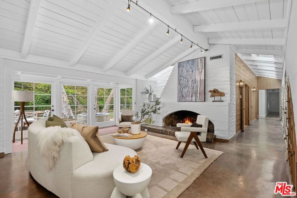 Sprawling over 26,285 square feet of property, this architectural rarity, all situated on one level, pays homage to the timeless origins of a Cliff May-inspired California ranch. Privately set back from the street, this property boasts exceptional outdoor space in the front yard as well as the backyard. The open, flowing floor plan showcases classic mid-century architecture with natural wood finishes, incredible slump stone walls, a spectacular architectural slump stone fireplace, and easy indoor-outdoor living. With two fully permitted horse corrals that are up to code, this home is perfect for equestrian enthusiasts or those looking for room to roam. Whether you're enjoying the serene canyon surroundings or exploring the possibilities for additional living space, this home offers a rare opportunity to live in one of Brentwood's most sought-after neighborhoods...Sullivan Canyon!