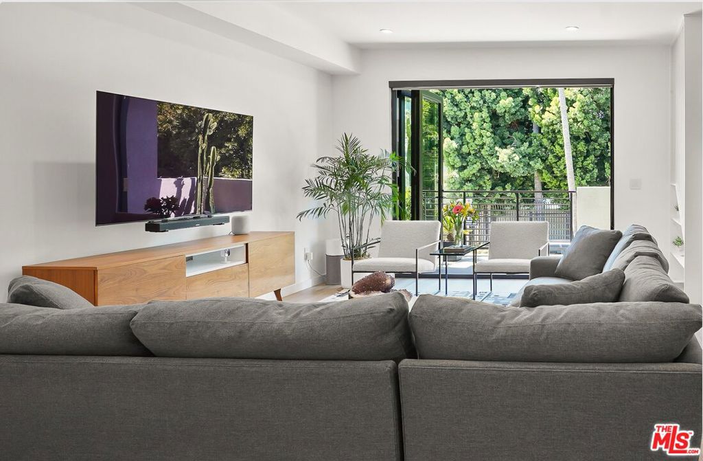Welcome to the crown jewel of Melrose Hill. Built in 2023, this detached multi-level residence offers modern luxury and every high-end feature you could imagine. With no attached or shared walls, this turnkey residence epitomizes comfort and style, offering the perfect balance of privacy and convenience. The open-concept main level is an entertainer's dream, featuring high ceilings, an abundance of natural light, and expansive floor-to-ceiling folding glass doors that open onto an oversized balcony perfect for al fresco gatherings. The gourmet chef's kitchen is a culinary masterpiece, boasting sleek quartz countertops, high-end stainless steel appliances, generous bespoke cabinetry, and a spacious walk-in pantry. A stylish powder room is also conveniently located on this level for guests. This home features 3 spacious bedrooms and 4 bathrooms, with each bedroom appointed with its own en-suite bath. Upstairs, the primary suite offers a spacious walk-in closet and a spa-inspired bath with dual vanities and an oversized walk-in shower. The second bedroom suite is impressively large and includes its own walk-in closet and full bathroom essentially functioning as a second primary suite. The lower level includes a third bedroom suite, ideal for guests or a home office and provides direct access to a private two-car garage equipped with custom built-in storage and an EV charger. The crowning feature is the sprawling private rooftop deck, presenting unparalleled panoramic views of the iconic Hollywood Sign, Griffith Observatory, and the Downtown Los Angeles skyline perfect for entertaining under the stars. Perfectly positioned in the heart of LA's creative industry, you are just blocks away from Paramount Pictures, Netflix Headquarters, and Raleigh Studios. Immerse yourself in the dynamic culture and renowned culinary scene of Melrose Hill. Walk to the Hancock Park Larchmont Farmers Market, savor Italian classics at Osteria La Buca, or enjoy a world-class meal at the two-Michelin-starred Providence. The highly anticipated Echelon Studios project just a block away, set to complete next year.