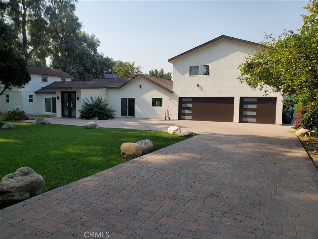 Contemporary paradise on just under an acre. This gated estate begins with an extended paver driveway leading through the peaceful, relaxing front yard. The home is mostly on one level, except for two newly built bedrooms with en-suite baths, a laundry room, and a bonus room. The first floor features an expansive open floor plan with a modern kitchen featuring a center island, dining area, formal living area, TV lounge area, and two master suites with en-suite baths. All bathrooms have been renovated in a contemporary style. The great room and master suite flow into the backyard with a large pool and spa. The 2-bedroom-bath guest house has a kitchen, including a dishwasher.
