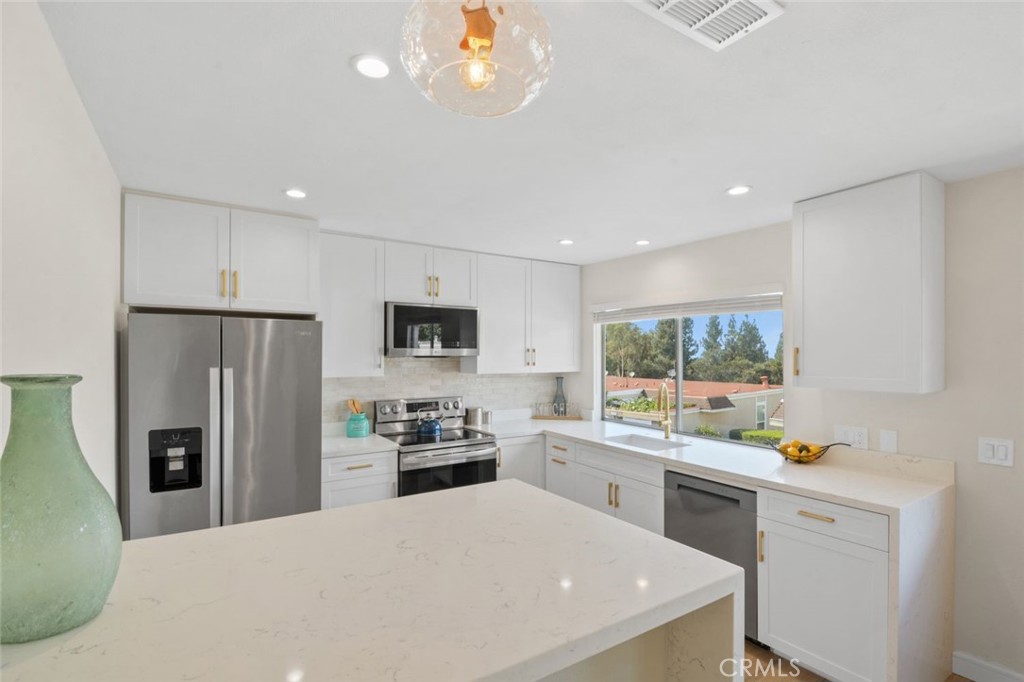 Do not use the unit number when planning directions. Fully remodeled end-unit townhouse in Laguna Hills filled with natural light and thoughtful design. This is the most desirable unit in the community, showcasing wide-plank light oak LVP floors, an open floor plan, and a striking mid-century modern steel fireplace that anchors the living space. The brand-new kitchen features white shaker cabinets with soft close, quartz counters with a waterfall edge, and a LG appliance package. Both bathrooms have been redesigned, including a primary suite with dual vanity, frameless glass shower, and a versatile built-in wardrobe. All bedrooms are on the same level, with a convenient laundry room right outside in the hallway.
Enjoy Saddleback Mountain views from this carriage-style home. Other recent upgrades include a brand new AC and furnace. The two-car garage attached garage and tons of extra storage making this floorplan highly coveted.
The community provides resort-style amenities including a pool, clubhouse, tennis and basketball courts, sand volleyball, and scenic walking trails through the hills. Ideally located just 10 minutes from the Irvine Spectrum and 15 minutes from Laguna Beach.
A rare chance to own a fully remodeled three-bedroom townhouse—the best floorplan in the community—for under $800,000. Also if looking for an investment this unit has incredible rent to value with recent model matches renting out for $3995 a month. Fence is a rendering and not on property but HOAs does allow fenced in patios with proper approval process. The fence is shown for potential use purposes only.