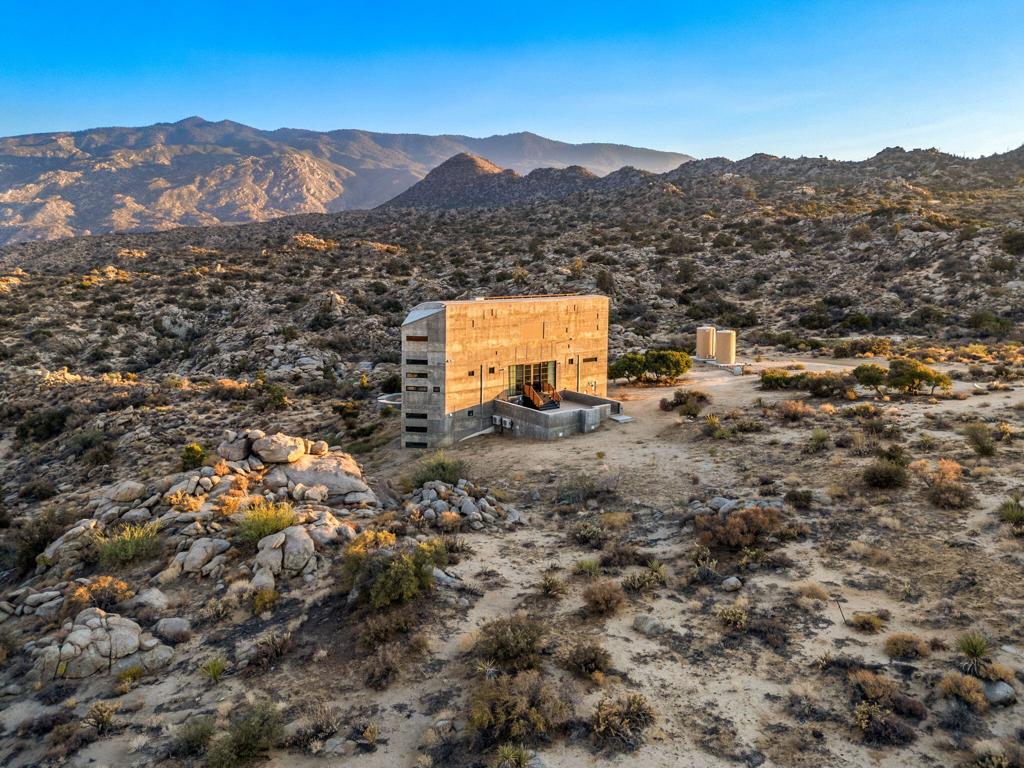 Discover a rare architectural treasure in the serene Pinyon Crest Community. Designed by renowned architect Charles Martin, celebrated for his visionary work on the Rancho Mirage Observatory and St. Garabed Armenian Church. This distinctive residence was originally envisioned as Martin's own personal retreat. Every line, angle, and space reflect his signature blend of innovative design and harmony with the surrounding landscape, creating a home that is as much a work of art as it is a place to live. With sustainability at its core, the home is thoughtfully designed with thermally broken walls for superior insulation, energy-efficient glazing for optimal comfort, and a state-of-the-art Tesla solar system to harness clean, renewable energy. The broader Pinyon Crest area carries a rich legacy as both a celebrity retreat and a canvas for remarkable architecture. From Frank Sinatra's former desert hideaway to an array of distinctive homesteads, this community has long attracted those seeking privacy, inspiration, and timeless design. Set on approximately 2.5 acres of rugged, rocky terrain, the residence commands attention with its Brutalist silhouette and raw, exposed concrete surfaces. Perched within view of HWY 74, it has become a quiet point of intrigue for passersby and a conversation piece among locals. Now, the home awaits a discerning new owner to bring the project to completion, offering the rare opportunity to infuse a master architect's vision with your own personal touch.