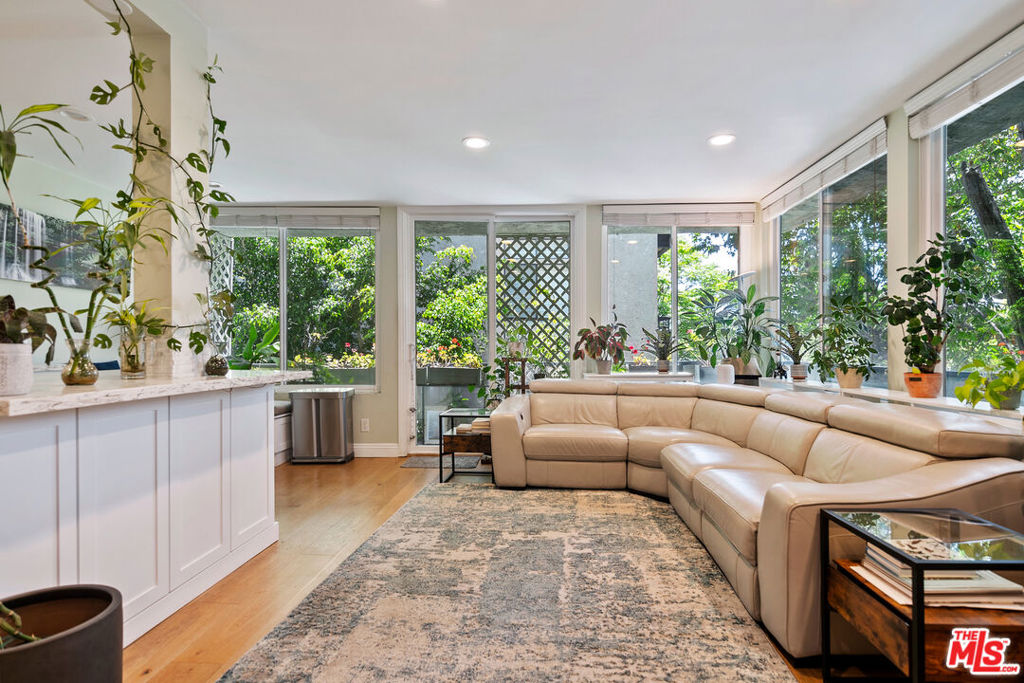 Sun-Drenched Corner Unit with SW Views & Private EV Charger! Welcome to this exceptional 1-bedroom, 2-bathroom corner condo in a quiet Westwood neighborhood, featuring expansive southwest-facing views framed by double-pane sliding glass windows, 14 in the living room alone! Bathed in natural light and cooled by gentle breezes, this bright and airy unit feels like a peaceful treehouse escape. Step onto the large wraparound balcony freshly repainted and resealed in 2025 perfect for enjoying your morning coffee or evening wine. Inside, you'll find stylish upgrades throughout: light-toned hardwood floors, a modern kitchen with quartz countertops, stone backsplash, and newer cabinetry, plus a marble-faced fireplace and recessed lighting. The spacious primary suite includes a beautifully remodeled bathroom with Porcelanosa Spanish tile in shower and a generous walk-in closet. The guest bathroom features a bidet toilet seat and a nicely sized shower. A cozy breakfast nook with built-in seating adds charm, and a cleverly added doggy door to the balcony makes this home pet-friendly. Modern comforts include a 2023 LG stackable washer & electric dryer, Nest thermostat, and refrigerator. Bedroom carpet boasts the thickest padding available for ultimate comfort. Walls are painted a soothing light green Feng Shui tone, creating a calming atmosphere. Bonus features include a private 240V EV charger dedicated to Unit 206 in garage space #9. The well-maintained building offers a stylish lobby, newer ADA-compliant elevator, and security camera monitoring. All this just moments from the shops and restaurants of Westwood, UCLA, and Century City. This is city living with tranquility, style, and convenience. Appraised over the current asking price in 2025, this is a rare opportunity to own a home with built-in equity. Don't miss it! Priced to sell!