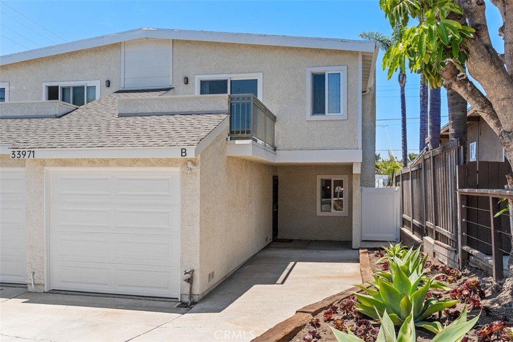 This turnkey 3-bedroom, 2.5-bath home offers approximately 1,400 square feet of light-filled living space, just minutes from Dana Point Harbor, shops, and restaurants. Located in the highly sought-after Lantern District, the home features high ceilings, an updated kitchen with new appliances, modernized bathrooms, fresh paint, and durable vinyl flooring throughout. What truly sets this property apart is the rare combination of a private, fenced-in backyard and a spacious balcony off the primary suite that's perfect for enjoying your morning coffee, and even catching a peek-a-boo ocean view. Additional highlights include a cozy gas fireplace in the living room, a direct-access single-car garage with full-size washer/dryer hookups, and a functional layout that feels both spacious and welcoming. This is easy coastal living in one of Dana Point’s most charming neighborhoods!