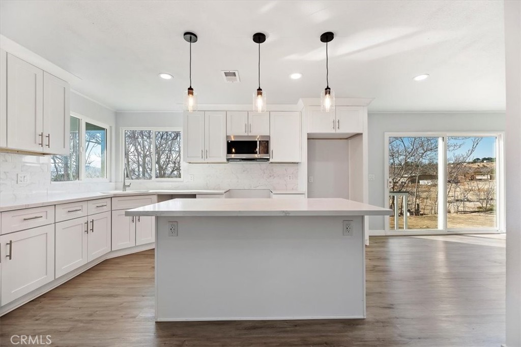 2.5-acre manufacturer property on a permanent foundation with fantastic upgrades! Step inside to a spacious, open-concept living area, where the kitchen and living room seamlessly flow together, creating a perfect space for entertaining and everyday living. featuring 3 bedrooms, 2 bathrooms with 2040 square feet of living space. The upgraded kitchen boasts with gorgeous countertops, stylish backsplash tiles, lovely light fixtures add to a touch of elegance, modern laminate flooring throughout, cozy fireplace, spacious laundry room area with a sink, and an abundance of cabinetry for storage, you'll have plenty of space to keep everything organized. This property also includes a private water well, offering added convenience and sustainability. Enjoy your morning coffee or evening relaxation on the inviting porch that overlooks the expansive 2.5 acre lot, with so much land you'll have plenty of room to enjoy outdoor activities, have farm animals and much more. This home combines comfort and style, offering a peaceful retreat with room to roam, with ample space both inside and out, this home is perfect for those seeking comfort, style, and privacy. Don't miss out on this incredible opportunity to own this home in a peaceful, rural setting!