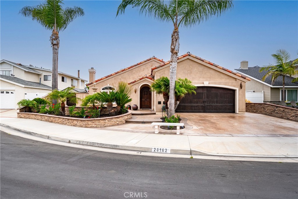 This exceptional home offers the best of coastal living, perfectly situated on a quiet interior cul-de-sac in one of South HB’s most desirable neighborhoods. From the moment you arrive, you’ll be charmed by the stunning curb appeal and welcoming private courtyard with a tranquil fountain, leading to a solid wood custom arched entry door. Inside, the spacious living room features recessed lighting and a beautiful fireplace, setting a warm and inviting tone. The chef’s kitchen boasts newer self-closing cabinetry with custom panel slide glides, leathered granite countertops, hammered copper farmhouse sink with designer fixtures, glass mosaic backsplash, and under/upper cabinet lighting. It opens seamlessly to the permitted expanded family room, creating a perfect flow for entertaining and daily living. Bamboo wood floors with travertine inlays carry you toward the backyard, where sliding doors invite you to enjoy true indoor/outdoor living. The covered patio and expansive entertainment space overlook the saltwater pool with a baja shelf, grotto, waterfalls, and fire bowls, plus a solar-powered palapa with built-in BBQ and outdoor TVs. The home’s bathrooms are equally impressive - the hall bath features travertine finishes, stone moldings, a bench seat, custom shampoo niche, stone vessel sink, wall-to-wall mirror, and a luxury shower with body sprays, handheld sprayer, and floating fixtures. The primary suite has been reimagined by removing an interior wall (formerly the 4th bedroom) to create a true retreat. The spa-inspired primary bath includes electronically heated stone floors, a Jacuzzi tub with illuminated waterfall fixture, and a separate custom stone shower with granite seat. Additional upgrades include a tankless water heater, newer HVAC system with all-new ductwork installed in the attic, copper re-piping throughout, and quality finishes that elevate every detail of the home. This is a rare chance to own a turn-key property in one of Huntington Beach’s most coveted communities—all just minutes from world-class beaches, parks, and top-rated schools.