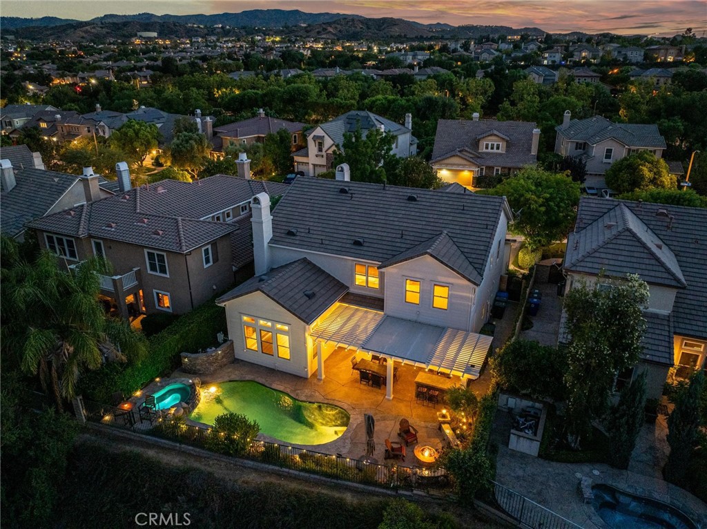 Welcome to Valencia’s prestigious Westridge Golf Course community where this Pool and view home looks out over the entire Santa Clarita Valley! This is the largest model in the popular Bent Canyon tract with 4 bedrooms & 3 full baths upstairs and a bedroom with private bath downstairs plus a 5th half bath for guests. 4-car garage too! This home has been updated and features plank style flooring, remodeled kitchen with quartz counters, stainless steel appliances, built-in refrigerator, trash compactor, large walk-in pantry and butler’s pantry with wine refrigerator. Very spacious and open to a large family room. Shutters throughout the house and nice crown molding as well. Upstairs are four bedrooms, two of which have private attached baths, one is oversized and currently used as an office with built-ins. Because the yard sits above the fairway and there are no rear neighbors it is exceptionally private and features a covered patio with cook station, fire pit and of course the pool & spa. Truly the perfect entertainer’s yard. Great yard, great view!