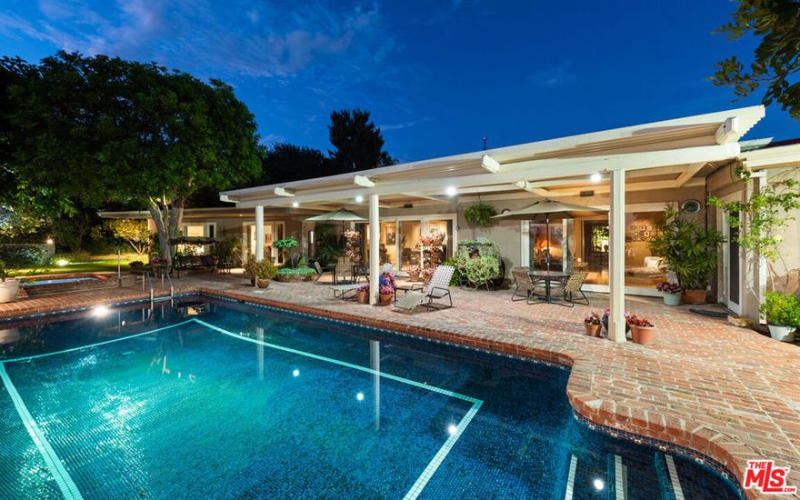 Behold this meticulously maintained and well preserved Hollywood Regency on one of the best streets in Trousdale Estates.  This single level home, awash with natural light, spans nearly 5000 square feet and is sited on a nearly half acre lot with stirring views of the canyon, ocean and city lights beyond.  Owned by one family since it was built, this home has an effortless floor plan with tall ceilings, which lends itself to the indoor/outdoor flow, perfect for large parties or intimate gatherings.  Chef's kitchen with professional appliances, center island butcher block, breakfast room, and direct access to the outdoor kitchen and pool patio.  Elegant formal living room and inviting family room with wet bar and projector with drop down screen are just adjacent to the formal dining room.  The bedroom wing of the home has 4 large en-suite bedrooms including enormous private primary suite with extensive closet space and large bathroom.  This home has been loved and enjoyed for over 5 decades, come bring your personal touch and elevate this special property to its full potential.