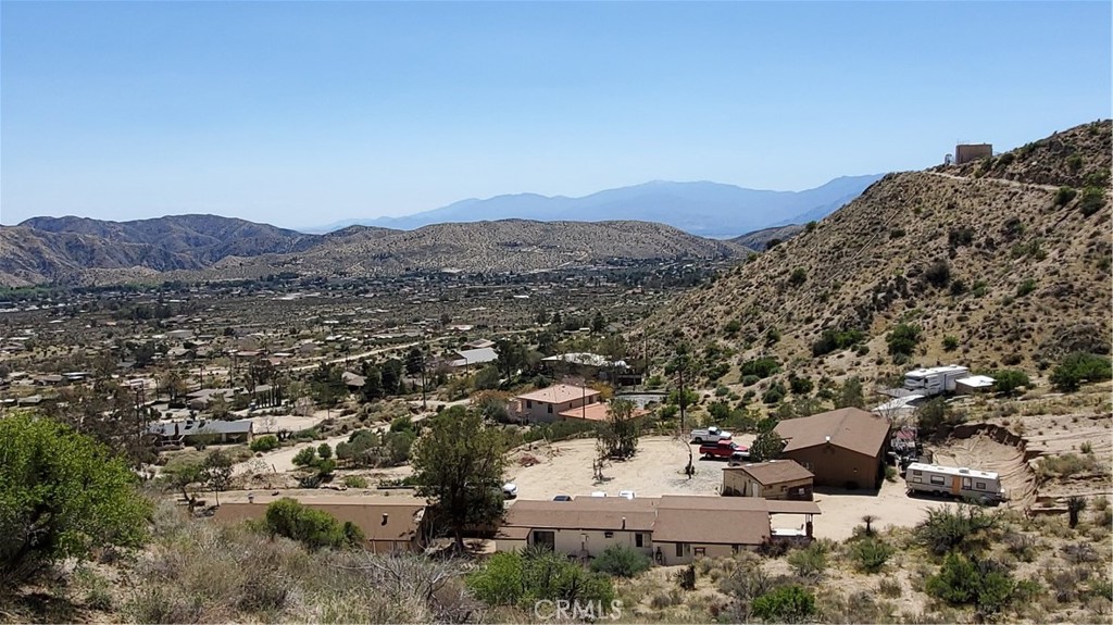 This is a one of a kind in the area! Featuring four complete dwellings. The main house is a 2 bed, 2 bath, 1,302 sq. ft. open floor plan wood plank flooring high ceilings with a fireplace in the living room. Mini split for heating and cooling. Wall of French doors open to a private front yard and a small pond with loads of fish. Laundry located in the common bathroom. En suite features a large walk-in-closet. Second stand-alone home on the property has 3 bedrooms, 1 bathroom, 1,400 sq. ft. Features high ceilings tile flooring front porch and an attached 2 car garage. The third dwelling is 2 bed, 1 bath 1,020 sq. ft. attached to a 2 bed, 1 bath 840 sq. ft. unit with a walk-in closet. All four of the self-contained living spaces have all electric stainless-steel appliances that will go with the sale. Property butts up to the San Gorgonio wilderness/Sand to Snow National Monument. Not likely to have anyone building above or beyond for years to come. Front views are very elevated looking into the Coachella Valley and the Santa Rosa Mountain range. Or towards the small town of Morongo Valley below. This property has so much to offer for a large extended family or as a potential rental income property. If you have questions feel free to inquire and if you would like to view this unique multi-unit gem. Contact the listing agent to make arrangements. Interior picture coming Sunday 3/23.
