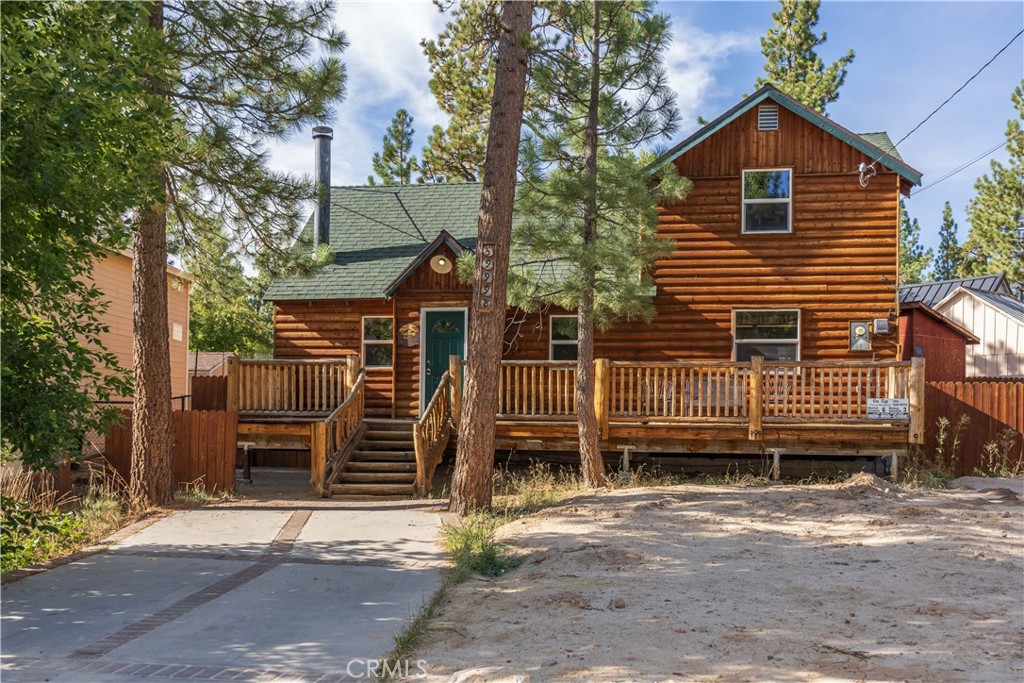 This 1,272 sqft full log-sided cabin beautifully blends rustic charm with modern conveniences, creating the perfect Big Bear getaway or investment. Thoughtfully updated, it features new flooring, stainless steel appliances, granite kitchen countertops, dual-pane windows, and central A/C for comfort year-round. The warm cabin décor enhances every room, including a spacious loft bedroom with closets that flows into the main bedroom, adding both character and functionality. Situated on a generous 7,777 sqft level lot, the property offers a newly fenced backyard for privacy, a storage shed, and plenty of outdoor space to relax or entertain. The inviting front porch is ideal for morning coffee, while the home’s location on a quiet street provides peace and seclusion. Just a short walk to the lake and Holloway’s Marina, and only minutes from the Village, hiking, biking, and ski slopes, this fully furnished retreat is move-in ready and captures the essence of Big Bear living.