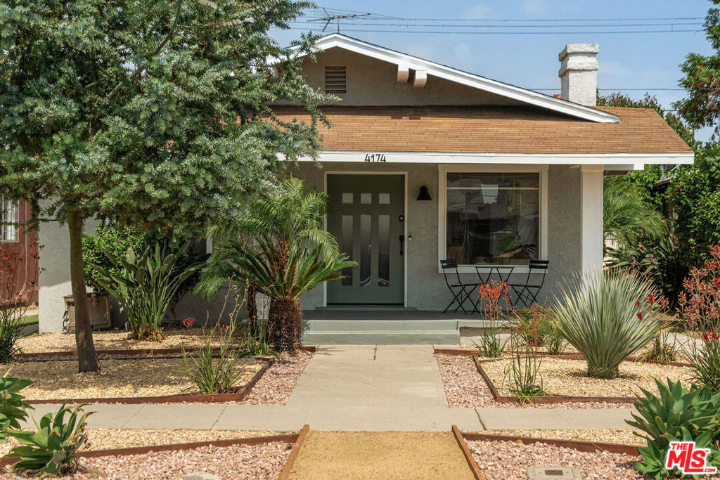 Welcome to 4174 Harvard Boulevard. Your new Los Angeles bungalow awaits! Colorful, native plants line the walk as you step onto your shaded porch. Step inside, and the home feels like a breath of fresh air. It's bright, spacious, and full of warmth. The inviting living room is anchored by a tasteful fireplace, stunning beamed ceilings and plenty of windows. Entertain with ease in the adjacent dining area, or pull up a stool in the well-appointed kitchen featuring generous counter space, ample cabinetry, and thoughtful details that make everyday cooking feel like a joy. Retreat to the guest room with a picture window that perfectly frames neighboring pines and sits adjacent to its own full bath. Continue down the hall to find respite in the primary suite. With two closets, one of which can double as a dressing room, and an en-suite bath, it offers both functionality and tranquility. As you head to the back door, you'll find a laundry room with a stacked washer and dryer. The fully fenced backyard is low maintenance and lined with privacy hedges, and a sizable shed plus a two-car garage offer the option for a future ADU without sacrificing storage space. Home updates include all-copper repiping and a brand-new central AC unit, providing added comfort and long-term peace of mind. Within the boundaries of the USC Neighborhood Homeownership Program and qualifying for City National Bank's Ladder Up Program, offering a $20,000 grant, this home is not only a smart investment, but it sits in the middle of some of LA's most exciting development. With world-class museums, including the upcoming Lucas Museum, as well as the Natural History Museum and Science Center, the USC campus, BMO Stadium, SoFi Stadium, the Forum, and the Intuit Dome practically in your backyard, you've got some of LA's best entertainment, sports, and culture just minutes from home. Grab empanadas or Argentinian wine at Fuegos LA, a crepe at Cafecito de La Crepe, or a coffee at South LA Cafe. This home is just minutes from West Adams, Jefferson Park, and Leimert Park. Check out the soon-to-be-opened Maydan Market, try to get a ticket for Lele Dinner Club, become a regular at Johnny's West Adams, Alta, Chulita, Tartine, Taqueria Los Anaya, Farmhouse Kitchen, All-Chill Ice Cream, Mizlala, Vicky's All Day, and more. Easy access to the Expo and Crenshaw Metro Lines puts DTLA, Culver City, Santa Monica, Inglewood, and now LAX within reach. 4174 Harvard Blvd isn't just a place to live. It's a front-row seat to the future of South LA...Come see it for yourself!