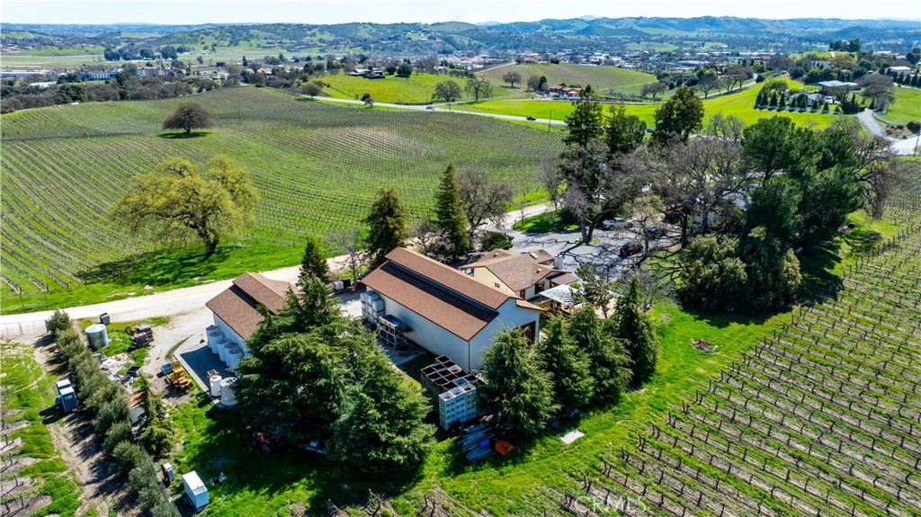 This is a fantastic opportunity to purchase one of the first wineries and tasting rooms along Highway 46 West, nestled within the Templeton Gap AVA. This 40-acre estate fronts Highway 46 West, with 36 acres planted with Malbec, Cabernet, Barbera, Merlot, and other varietals.
The improvements include a residence, tasting room, production and storage buildings, and beautifully cultivated vineyards along the scenic highway. The 2,100-square-foot residence is also situated on a knoll, providing stunning views of West Templeton and the Santa Lucia Mountains. This three-bedroom, two-bath home features an open-concept living area, a stacked stone fireplace, engineered reclaimed barn wood flooring, and much more. The 12' x 60' deck is an excellent outdoor entertaining space.
Some believe this location served as the headquarters for the original Spanish land grant, though that remains unconfirmed. The winery has been operational for approximately 27 years and has a use permit for a 15,000-case capacity. The tasting room is about 1,100 square feet, complete with a bar area, retail space, and an ADA-compliant bathroom.
Outside, you will find two insulated production and storage buildings featuring a backup generator, measuring approximately 2,500 square feet and 1,280 square feet, respectively. The property has an 8-inch well with a 30-horsepower variable pump, a filtration system, and an irrigation well. The additional three legal parcels each have wells that are not currently in use.