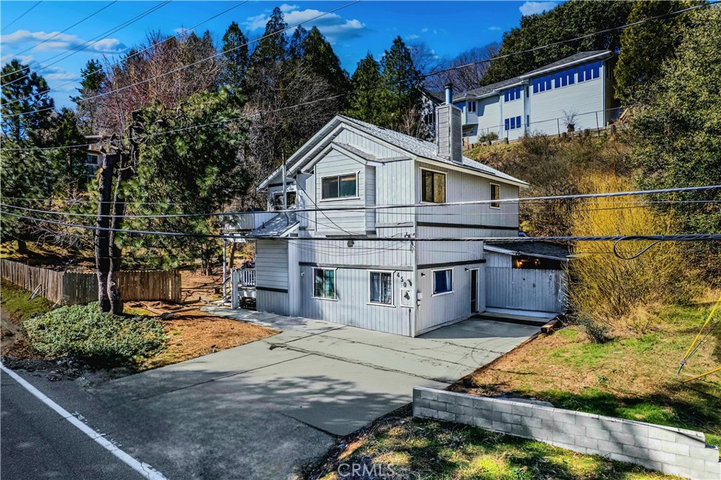 Welcome to 450 S. Dart Canyon Road! This beautiful 5 bedroom, 2 bathroom home offers 2,122 sq ft of bright, open and airy living space as well as two additional bonus rooms and an ideal floor-plan for an in-law suite. Nestled on nearly a half an acre lot, the rear yard is a rare find in the mountain community with endless possibilities! Enjoy the outdoors, breathtaking panoramic views of the surrounding mountains and towering trees, soak in the sparkling jacuzzi, and unwind under the stars after a day of adventure. Perfect for a full-time residence, a vacation getaway, or a short-term rental investment; this home truly has it all! Located just a short walk to Lake Gregory, you will have easy access to family-friendly activities such as hiking, fishing, boating, swimming, summer jamboree days at the lake and the San Moritz Lodge. Shopping, dining and entertainment are only minutes away and convenient access to HWY 18 and HWY 138 will make commuting a breeze. Recent upgrades to the home include: a NEW roof, NEWLY renovated and freshly painted front porch and second floor balcony, fresh paint on the interior, a NEW water heater and regularly serviced septic system. Property features include: a cozy wood burning fireplace, an oversized kitchen island open to the dining room, an abundance of kitchen cabinetry and storage throughout the home, a spacious primary bedroom with a large walk in closet, indoor laundry area, renovated bathrooms, spacious storage shed/ workshop, a 3 car street-level driveway, potential for RV and boat parking, charming front porch and balcony, an oversized fenced in lot and a relaxing covered jacuzzi. LOW taxes, and NO HOA. Don’t miss this opportunity to own a piece of mountain paradise- schedule a private tour today!