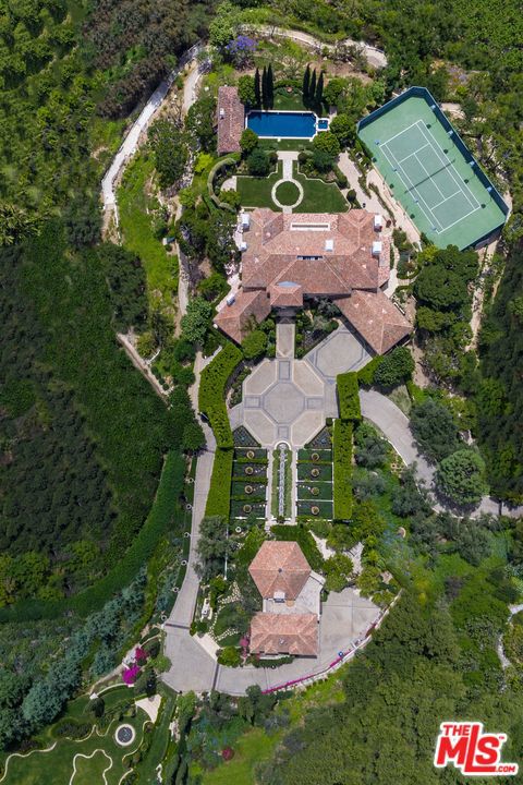 Nestled over 5 verdant acres in the hills of Bel Air rests this hidden estate, transporting all who enter to the enchanting countryside while moments from the city. Offering total privacy for the most discerning, property sits at the end of a quiet cul-de-sac within an exclusive enclave, behind gates that open to a motor court flanked by the magnificent main house & cascading water feature/upper pavilion. The extensive grounds, comprising of 2 legal parcels (each 2+ acres w/separate APNs), encompasses 2 detached guest houses (1,000 & 3,000 sqft), N/S tennis court, pool cabana & lush expanses of lawns, gardens & paths leading to secreted troves w/soaring views. The main dwelling, w/high ceilings and bright, light-filled spaces, is perfectly proportioned to accommodate large-scale entertaining and nurture harmony in everyday living. A sense of warmth pervades throughout, complemented by rich detailing & panoramic views while offering all the amenities of a premiere, first-class estate.