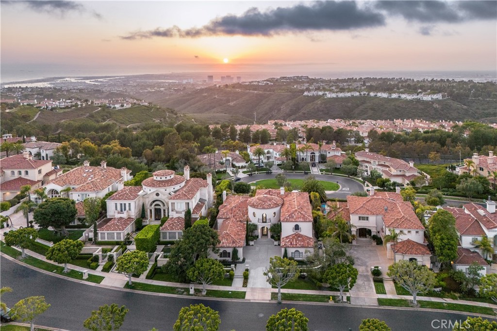 Perched in the prestigious guard-gated community of Pelican Ridge Estates, this newly renovated coastal sanctuary rests at the end of a serene cul-de-sac, capturing breathtaking ocean and canyon views from nearly every angle.
Blending architectural sophistication with modern elegance, the residence spans approximately 4,710 square feet and offers 4 bedrooms, 5 bathrooms, and a thoughtful layout that seamlessly integrates indoor and outdoor living. Grand double-height ceilings, custom casement windows, and wide-plank European oak flooring lend timeless warmth and natural light throughout.
The heart of the home is a contemporary Leicht-designed kitchen featuring two-toned cabinetry, veined quartz countertops, and premium appliances—including a paneled refrigerator—flowing effortlessly into a sunlit family room with French doors that invite in the coastal breeze.
Entertain in the dramatic formal living room, where soaring ceilings create an ambiance of grandeur, or host intimate gatherings in the elevated formal dining room enhanced by striking designer lighting. Three main-level bedrooms each enjoy tranquil views—either of lush greenery or the Pacific Ocean—and include exquisitely designed en-suite baths.
The upper-level primary suite is a private retreat with its own sitting area, fireplace, and a secluded balcony overlooking Newport Coast’s most iconic vistas. The en-suite bathroom offers spa-like indulgence, complete with an oversized soaking tub, a sprawling steam shower, and refined designer finishes.
Set on an expansive 11,200 square foot lot, the outdoor living spaces are designed for both relaxation and entertainment. Panoramic ocean views set the backdrop for a BBQ kitchen, multiple lounge patios, and an infinity-edge spa framed by tropical landscaping and stylish hardscaping.
Pelican Ridge offers residents premier amenities including a resort-style pool and spa, tennis and sport courts, playgrounds, and access to scenic hiking trails. Ideally located moments from world-renowned beaches, Fashion Island, championship golf courses, and major thoroughfares, this is coastal luxury living at its finest.