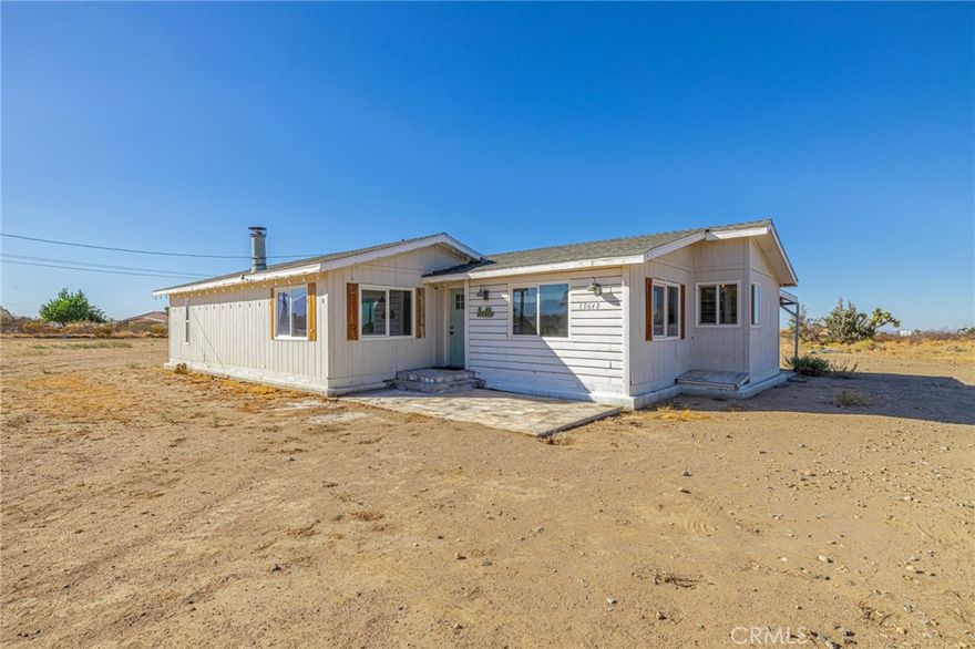 Welcome to 10648 Sycamore St in Victorville! This spacious 3-bedroom, 2-bath manufactured home offers 1,812 sq. ft. of comfortable living space on a generous 2.2-acre lot, perfect for anyone seeking peace, privacy, and room to grow. Set on a permanent foundation, this home features an open floor plan with bright living areas and plenty of natural light. The large kitchen provides ample counter and cabinet space, ideal for cooking and entertaining. Enjoy the comfort of central heating and an evaporative cooler, along with a newer roof and durable construction. Outside, the expansive flat lot offers endless possibilities, add a workshop, garden, or even another structure (buyer to verify). With plenty of space for RV parking, animals, or outdoor recreation, this property captures true High Desert living. Conveniently located near schools, shopping, and major highways, 10648 Sycamore St combines rural tranquility with everyday convenience.