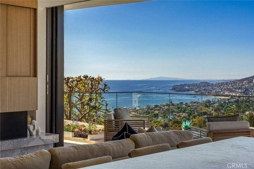 A scenic expanse of coastal life and the sparkling Pacific unfold before a rare 52’ of unobstructed view frontage, crowning this newly constructed Contemporary-style residence. Every aesthetic and structural element was considered in composing this collection of elegant, yet comfortable spaces,
along with the value of future opportunities for an expanded domain, incorporating additional living accommodations on-site. The offering includes fully approved plans and permits to build an 850-sq.- ft. dwelling (ADU) with sweeping views and convenient accessible parking located just above the parcel on Crest View. A significant portion of the ADU preparation has already been completed. The 3,215 sq.-ft. home with four bedrooms, four en-suite baths, a powder bath, an open living room and kitchen, and a formal dining room and bar is a feat of technical engineering – carefully executed without a single square foot of wasted space. All of the living areas present experiences enhanced by captivating views through ‘walls’ of glass, and access to generous terraces surrounded by ‘floating’ gardens. An abundant assemblage of amenities were employed to enrich the inhabitants’ lifestyle opportunities – a small selection includes: generous appointment of White Oak, Limestone, imported slab stones, Cleaf Italian cabinetry, and a ‘floating’ system of walls and soffits with concealed lighting; resort-inspired baths in every suite; three Western pocket doors spanning 32’ and 22’; an 8’ linear fireplace in the main living room; Thermador appliances; service pantry equipped with built-in coffee/espresso and microwave/warming; an entry-level guest suite; a
stunning primary suite with a statement bath clad almost entirely in book-matched slab stone with a free-standing soaking tub, a walk-in wardrobe, and a 6’ linear fireplace. Additional technical advancements and offerings include construction comprised of 70% concrete and steel with the application of 40 caissons; an elevator servicing all four levels; a 16’ two-car garage with capacity for two lifts for additional vehicles; four-zone HVAC; home automation for light, sound, and window coverings; and a custom-built exterior steel stair enabling access to the uppermost point of the premises – affording a spectacular panorama. This symphony of refined design and architectural sophistication delivers an environment to enjoy the benefits of thoughtful amenities in concert with the splendor of the natural setting.