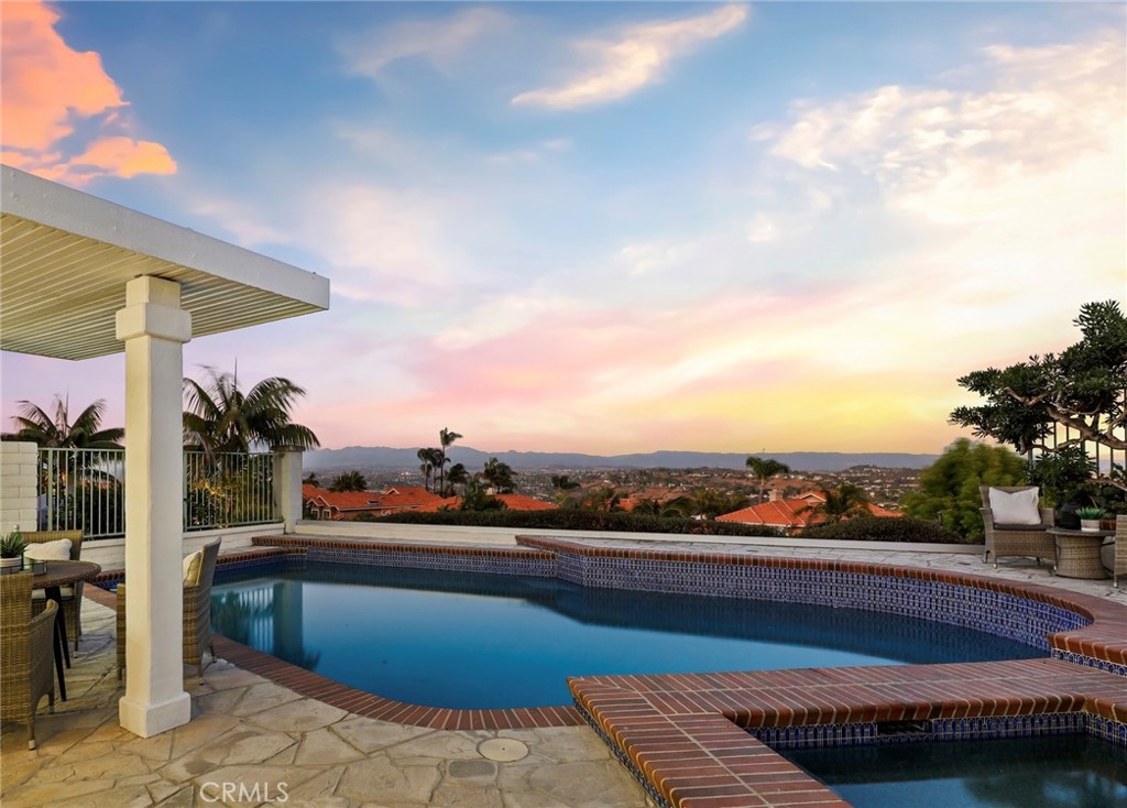 Discover unparalleled coastal living in this meticulously renovated 3-bedroom, 2.5-bathroom home nestled within the prestigious Niguel Summit community of Laguna Niguel. Spanning 2088 square feet, this stunning residence boasts panoramic vistas stretching from Saddleback Mountain to the Pacific Ocean. Step inside to discover a beautifully redesigned interior featuring a cozy fireplace in the family room, complemented by chic lighting fixtures. Just upgraded with new windows, doors, and fresh paint, along with gorgeous porcelain tile floors, the home exudes modern elegance and comfort. The gourmet kitchen is a culinary delight, showcasing quartz countertops, sleek white shaker cabinets adorned with gold hardware, an eat-at island with stylish grey cabinets, and state-of-the-art appliances including a wine fridge. Luxury awaits in the primary suite, complete with a spacious walk-in closet, a sumptuous soaking tub, a separate step-in shower, and dual sinks overlooking scenic vistas. Ideal for entertaining, the newly surfaced pool with a tranquil jacuzzi and water feature beckons relaxation amidst breathtaking views. Additional highlights include two secondary bedrooms with updated glass slider closets, an updated hall bath with a large skylight-lit step-in shower, and luxury vinyl flooring throughout the upstairs for a touch of refinement. Enjoy the ultimate in privacy with a front gated courtyard entry and the convenience of direct access to a 2-car garage and a 2-car driveway. Located on a single loaded street, this home offers serenity and exclusivity in one of Laguna Niguel's most coveted neighborhoods. Perfectly positioned near Monarch Beach, Dana Point Harbor, and the vibrant cultural scene of Laguna Beach, residents will relish easy access to world-class beaches, renowned hiking trails, golf courses, and upscale shopping and dining options. With top-rated schools nearby, this is an exceptional opportunity to experience Southern California coastal living at its finest.