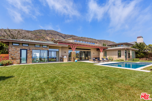 Private luxury Marisol contemporary ranch style Estate. This fully automated home offers luxury coastal living at its finest with head on Pacific Ocean Views. Secluded behind private gates, this Estate features four bedrooms all with ensuites, an opulent Master Wing, private home gym, wine cellar, media room with built in speakers, home office all incorporating elegant modern amenities with seamless indoor and outdoor living flow. You feel like you've stepped into an island resort as you enter the master bedroom wing with vaulted ceilings, whitewash pine floors, sun drenched ocean views and master bathroom with soaking tub, shower, custom double vanity, his and her closets, and see-through fireplace. Living room with gorgeous custom Fleetwood doors overlooking the built in BBQ & outdoor kitchen, pool with spa, & hammock. Chef's kitchen with Caesarstone countertops, teak veneer cabinets, & stainless steel Wolf/Sub Zero appliances. Resort style grounds complete this Malibu dream home.