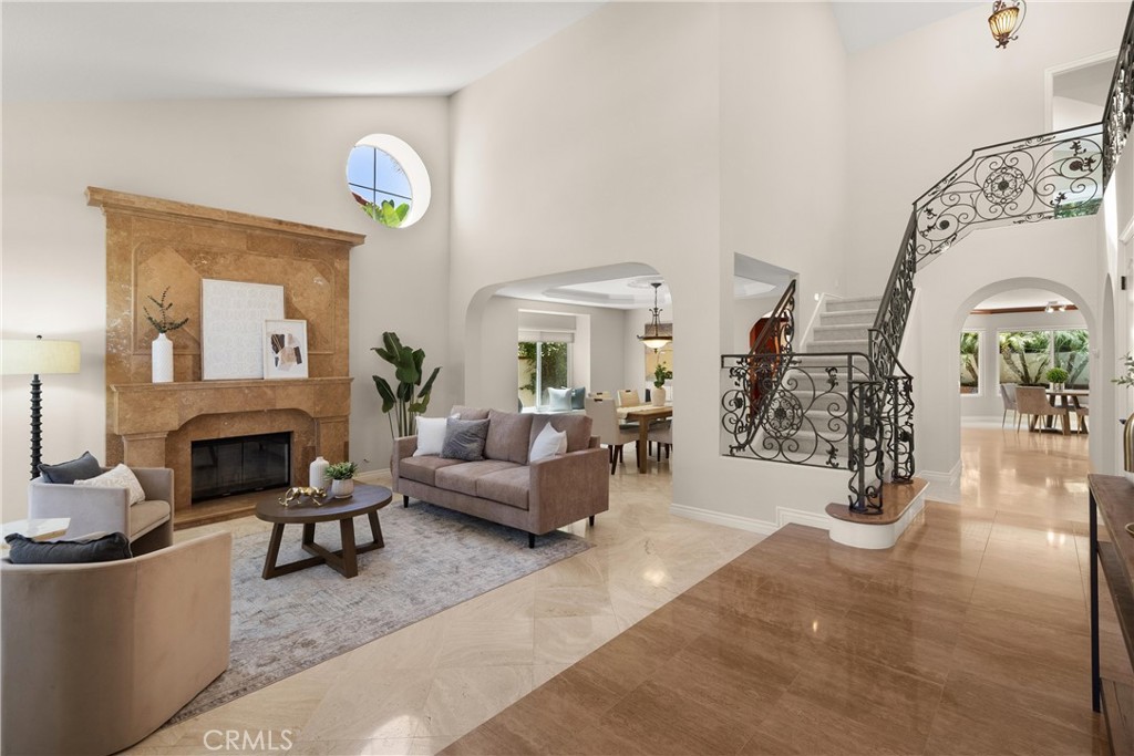 This beautifully upgraded Estate II District home, built by S&S Homes, is located in the sought-after East Lake Village community of Yorba Linda. With 4 bedrooms, 3 bathrooms, and a large bonus room (or optional 5th bedroom), this spacious home offers approximately 3,850 sq ft of thoughtfully designed living space that blends comfort, elegance, and functionality. Step inside to find soaring ceilings, travertine flooring, and a formal living room with fireplace and tall windows. The adjoining formal dining room features crown molding and a built-in wine fridge, creating the perfect space for entertaining. At the heart of the home is a chef’s kitchen with granite counters, wood cabinetry, center island seating, and a WOLF 6-burner stove with pot filler. The kitchen opens to a welcoming family room with fireplace and oversized sliding glass door leading to the backyard. A downstairs bedroom with marble floors and direct backyard access is ideal for guests or a home office. A full bathroom and dedicated laundry room complete the main level. Upstairs, the primary suite is a true retreat—offering a fireplace, walk-in closet, newer windows, and a private balcony. The ensuite bath includes dual vanities, a walk-in shower, and ample storage. Two additional bedrooms upstairs (one with vaulted ceilings) share a full hall bath with granite counters and travertine flooring. A spacious bonus room with vaulted ceilings, the home’s fourth fireplace, and a wet bar adds flexibility for a media room, lounge, or game room. Enjoy a private backyard oasis featuring an Alumawood patio cover with fan, sparkling pool and spa, lush landscaping, a lemon tree, and plenty of space for outdoor living. Additional upgrades include a newer roof and electrical panel. East Lake Village offers resort-style amenities including pools, clubhouse, tennis, gym, lake trails, and more—all within award-winning PYLUSD.