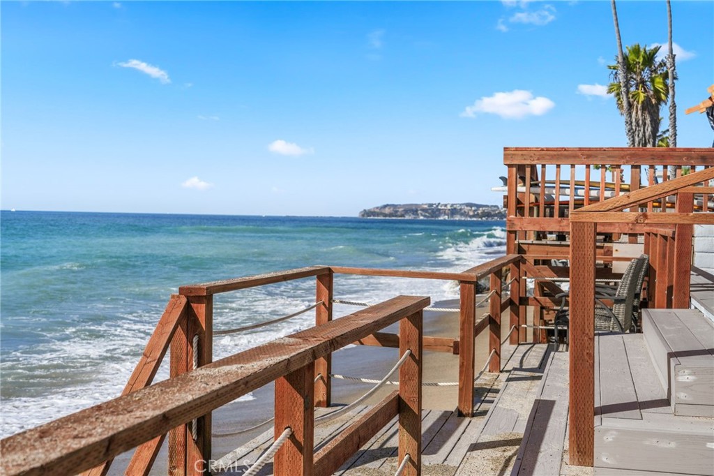 Set along the sand in the exclusive, guard-gated enclave of Beach Road in Dana Point, this oceanfront property offers a rare opportunity for investment or personal enjoyment. Currently arranged as a duplex, the single-level structure hosts two updated three-bedroom, two-bath units—each with direct beach access and sweeping views of Catalina Island, the Pacific Ocean, stunning sunsets, and Dana Point’s iconic Headlands. Together totaling approximately 2,106 square feet, both units showcase open-concept living with tile flooring, soaring ceilings, indoor laundry, and spacious living areas that open to patios overlooking the ocean. The kitchens have been modernized with granite countertops and stainless-steel appliances, while upgraded windows and sliding doors invite in natural light and sea breezes. A recently updated deck adds durability and long-term value. Sitting on a homesite more than 100 feet deep and over 6,000 square feet in size, the lot extends all the way to the median high-tide line—an extraordinary advantage for California coastal real estate. Whether you choose to rent both units, live in one and lease the other, or build a custom oceanfront retreat, the possibilities are abundant. Beach Road spans nearly 1.5 miles of private beach and features approximately 185 residences. Its unmatched location offers easy access to Dana Point’s Lantern District, harbor, beaches, coastal trails, shops, restaurants, and nearby destinations including Laguna Beach and San Clemente.