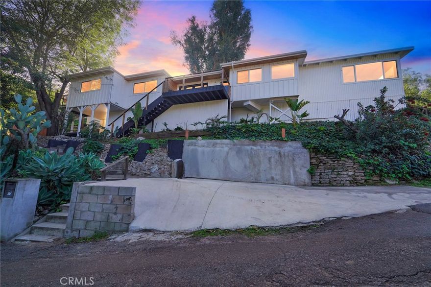 Located in the desirable Hollywood Dell pocket of Los Angeles, this 1958 split-level post-and-beam home sits on a rare 12,514 sq ft lot surrounded by mature foliage, offering exceptional privacy and a true hillside feel. The 2,383 sq ft residence features 4 bedrooms and 2 bathrooms, with a flexible layout designed for indoor-outdoor living.

The main level includes an open entry with deck, a light-filled kitchen, adjoining den, two spacious bedrooms, and a full bath, plus a bonus room accessed by a private staircase. The lower level offers a family room with a wood-burning fireplace, an additional bedroom and bath, and hidden bonus storage or workspace. Multiple balconies and access points lead to a private, sunlit pool and deck nestled among the trees.

The oversized lot presents potential for additional living space, ADU, or landscape enhancements. Notes: the property has no garage, consists of three tied lots, and certain improvements—including the carport, front parkway, and select bonus areas—have city compliance issues.