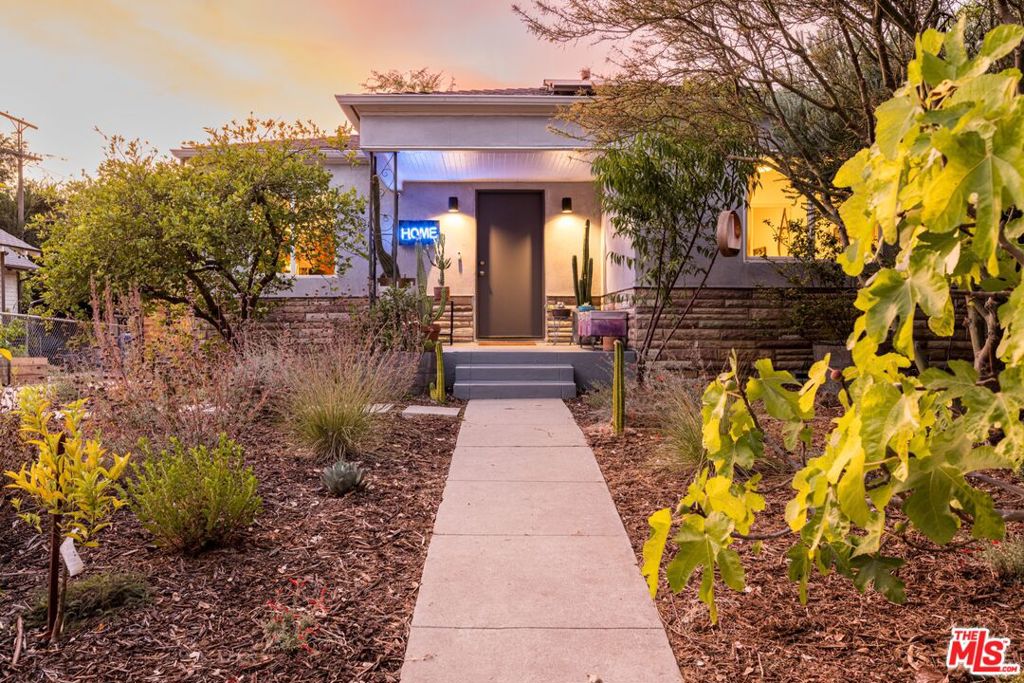 A secret retreat in Highland Park, this three-bedroom, two-bathroom sanctuary balances the rhythm of daily life with the quiet pull of nature. Light fills the interiors, moving easily from living room to dining to kitchen, with wood floors anchoring each step. The galley kitchen is fit for a crowd, designed for cooking and connection, while the home itself feels made for gathering, an easy transition from dining room into living space. Thoughtful updates and design elements throughout bring a sense of care and intention to every corner. The primary bedroom sits at the back of the home, calm and tucked away, with en suite bath and soft light. Two additional bedrooms and a second bath complete the layout, simple and balanced. Solar panels further enhance the home, blending sustainability with everyday comfort. Outdoors, the garden becomes the story planted with more than thirty varieties of trees, vines, herbs, and shrubs. Avocado, persimmon, fig, and peach are among the many trees that grace the enclosed front yard, while blueberry and blackberry bushes edge the path. Grapevines trace the side of the house, and passion fruit climbs the fence line, a reminder that this is a place that shifts with the seasons, always growing, always abundant. Step into the yard and the pace changes. Under mature Chinese elms, a cedar sauna lined with Himalayan salt bricks, an outdoor shower, a cold plunge, and a fire pit create space for restoration and gathering. A pergola shelters long table dinners, while a lounge and projector screen invite evenings outdoors. At the garden's center, a twelve-sided wooden yurt rises, skylights opening to the sky above, sheepskin rugs layer the floor. Originally built for tea ceremonies, it's ready for whatever is needed - yoga, writing, quiet reflection. It feels both rooted and apart from the city, while still just moments from the energy of Highland Park's newest stretch: Sam's Place, Gloria's Cuisine, Carla's Fresh Market. It's that rare balance- city at your doorstep, sanctuary at home.