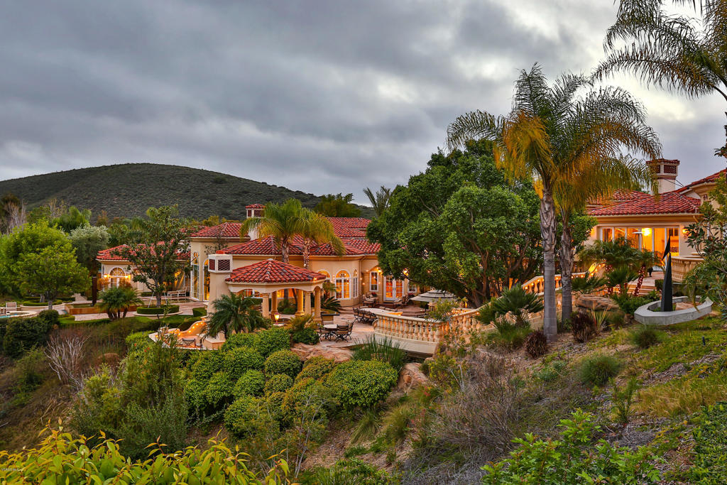 Located in the prestigious private community of North Ranch Country Club Estates, this Mediterranean inspired home is a luxurious yet comfortable home defined by a wealth of spectacular custom design elements. The approx. 15,835 sq. ft. 6 bedroom, 11 bathrooms estate that sits on 4.3 acres includes a family room, living room, formal dining room, a spectacular 2 level library with impressive architectural detailing, a playroom, indoor racquet ball court / basketball court, a subterranean temperature controlled wine room, & an impressive two-level theater/game room. The magnificent rear grounds are completely private & serene, offering a variety of distinctive & separate areas to enjoy a vacation-like escape; including a tropical lagoon with a cascading waterfall & 120' slide, pool house,full tennis court with a viewing pavilion, streams, lounging terraces, two fully equipped grilling/kitchen stations with a pizza oven. An extraordinary property!