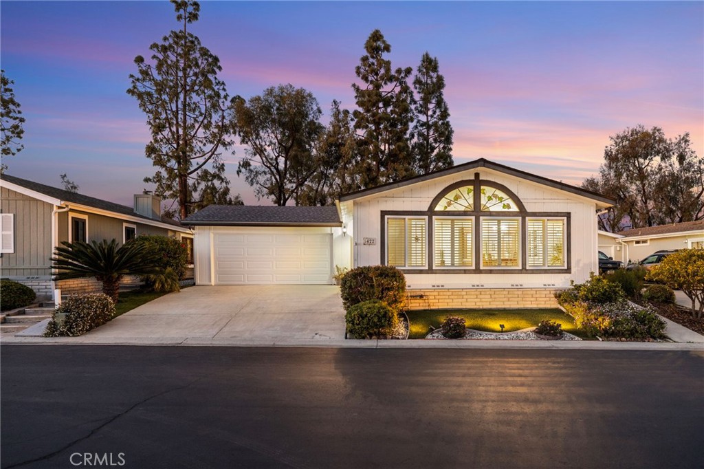 Beautiful home perched on a knoll and cul-de-sac in the gated 55+ community of Camino Hills, with double attached garage and sunroom. Hidden gem, on a cul-de-sac, nestled in the hills of Carlsbad amongst multi-million dollar homes. You own the land with this desirable manufactured home. High ceilings and abundant light welcome you to this roomy two-bedroom, two bath home with central/forced air and dual pane windows. The living room and dining room feature plantation shutters. There is a large family style kitchen with RO water system and walk-in pantry. It offers generous cabinetry for storage and counter space to prepare food. The gorgeous master ensuite and sunroom both offer views of the yard with pine trees and nature. The bright and airy sunroom, included in the square footage, provides easy access to your double car garage and beautiful yard. The master has two closets and large bathroom with dual sinks, separate tub, and walk-in shower. The 2nd bedroom also features a large closet, and bathroom with walk-in shower. The Home has a separate laundry room with plentiful cabinets and a utility closet. The Double car attached garage offers a workbench, room for 2 cars and storage as well as direct access to the home. There is a lovely landscaped yard, with automated sprinklers for easy maintenance to care for the beautiful flowers, trees and plants. Side landscaping includes two newer shared avocado trees, along with an orange tree in the front. The roof is newer, just 5 years old, and the home has rain gutters. The Community offers many amenities that include a beautifully landscaped clubhouse, perfectly heated pool, spa, tennis courts, gym, RV parking for a fee, and more. HOA is active and organizes fun and frequent events. Camino Hills has a strong sense of neighborhood community. To see, just look up Camino Hills HOA on the internet. Homes in this community with garages rarely come on the market. Make Spencer Lane yours!