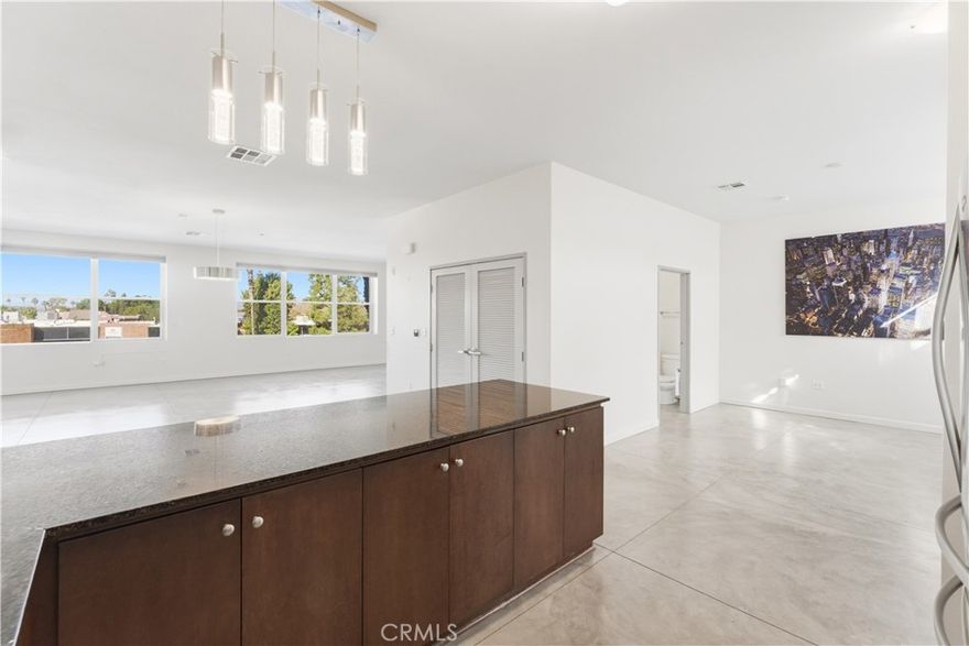 Experience authentic New York-style loft living in the heart of Anaheim’s most vibrant urban district.

This stunning true loft boasts soaring 14-foot ceilings, and massive industrial-style windows that flood the space with natural light and frame dramatic city views. The expansive open-concept floor plan (over 1,600 sq ft) flows effortlessly from the sleek chef’s kitchen with stainless steel appliances and granite counters to the generous living and dining areas, perfect for entertaining large groups or hosting unforgettable gatherings. 

Polished concrete floors, automatic blinds, and a neutral modern palette give the home an unmistakable downtown NYC edge while enjoying the laid-back Southern California lifestyle. The primary suite features expansive closet space with a walk in closet plus secondary closet, and bathroom with dual vanities. A second bedroom space and a stylish guest bath create a loft like and thoughtful layout. Completing the space is an extra den that can be used as a third room or office.

Step outside your door and you’re in the middle of Anaheim’s hottest scene: rooftop bars, craft breweries, acclaimed restaurants, live music venues, and the Anaheim Packing District, all just blocks away. Easy access to Disneyland, Angel Stadium, Honda Center, and the ARTIC transportation hub make this the ultimate lock-and-leave hub or full-time entertainer’s dream.

Rarely available true urban loft that includes two secure tandem parking spaces equipped with dedicated electric vehicle charging, in-unit laundry, and resort-style community amenities. This is loft living, reimagined for the modern Anaheimite who wants the energy of the city without sacrificing space, style, or sustainability.